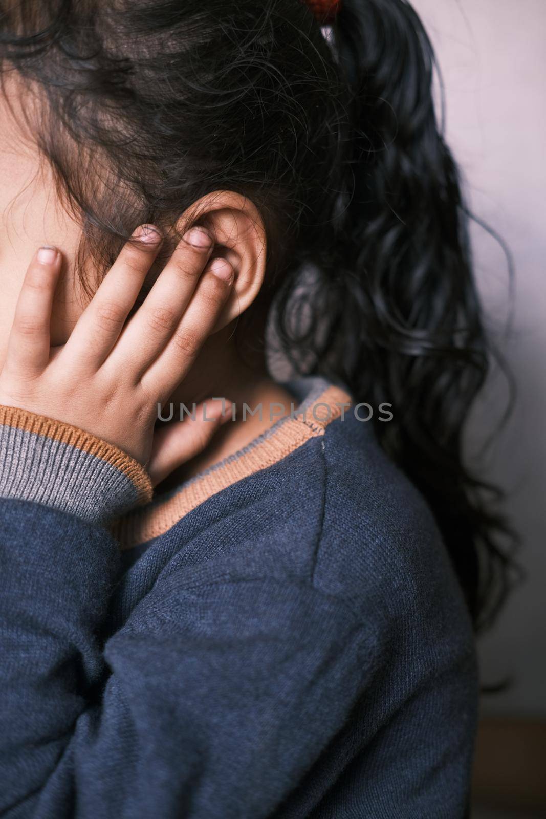 child girl having ear pain touching his painful ear ,.