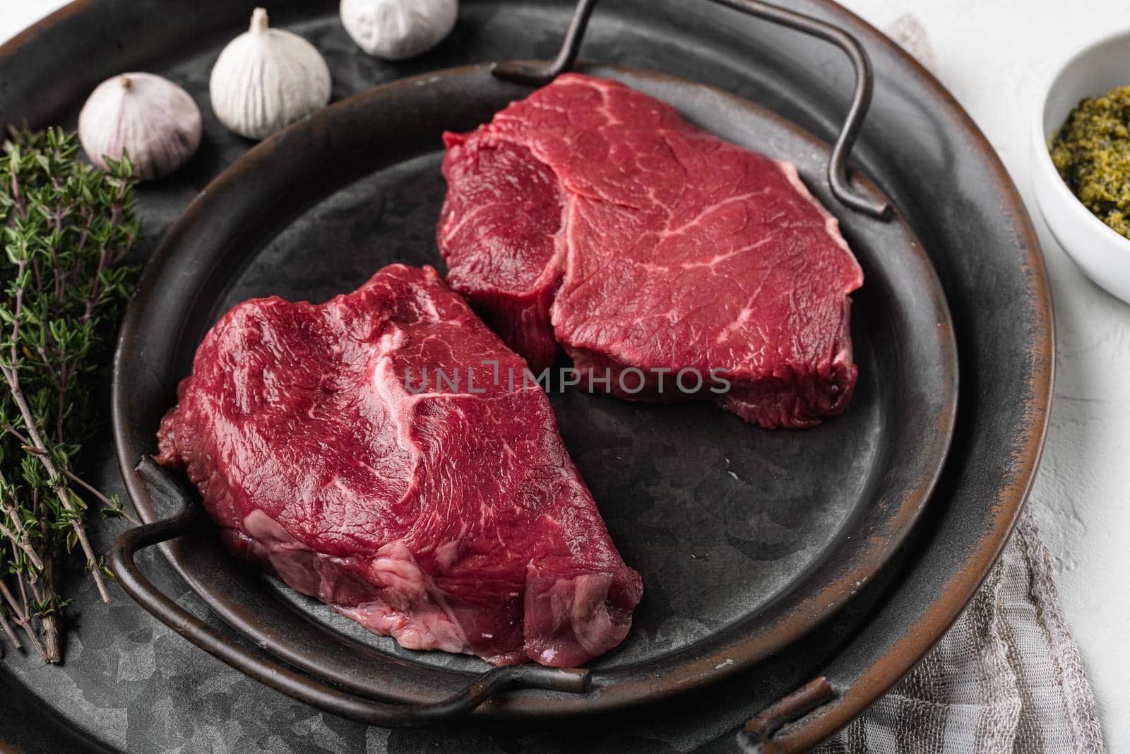 Beef raw rump steak with salt pepper rosemary set, on white stone table background