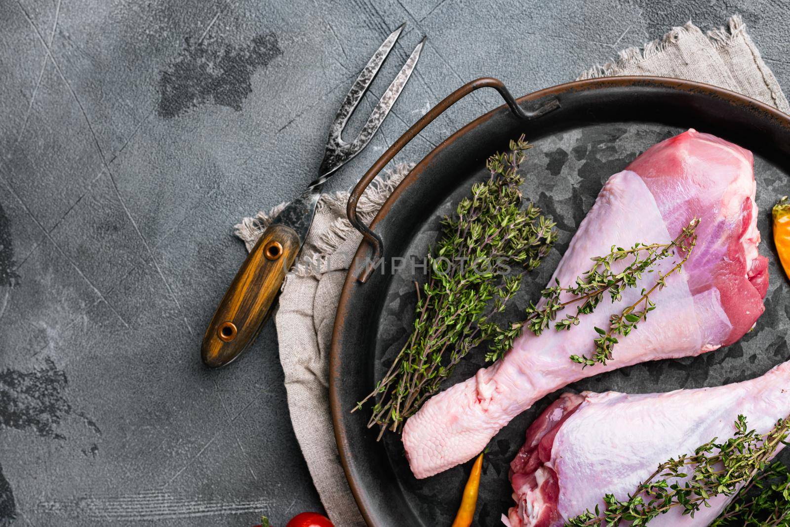 Turkey raw meat leg, on gray stone table background, top view flat lay, with copy space for text