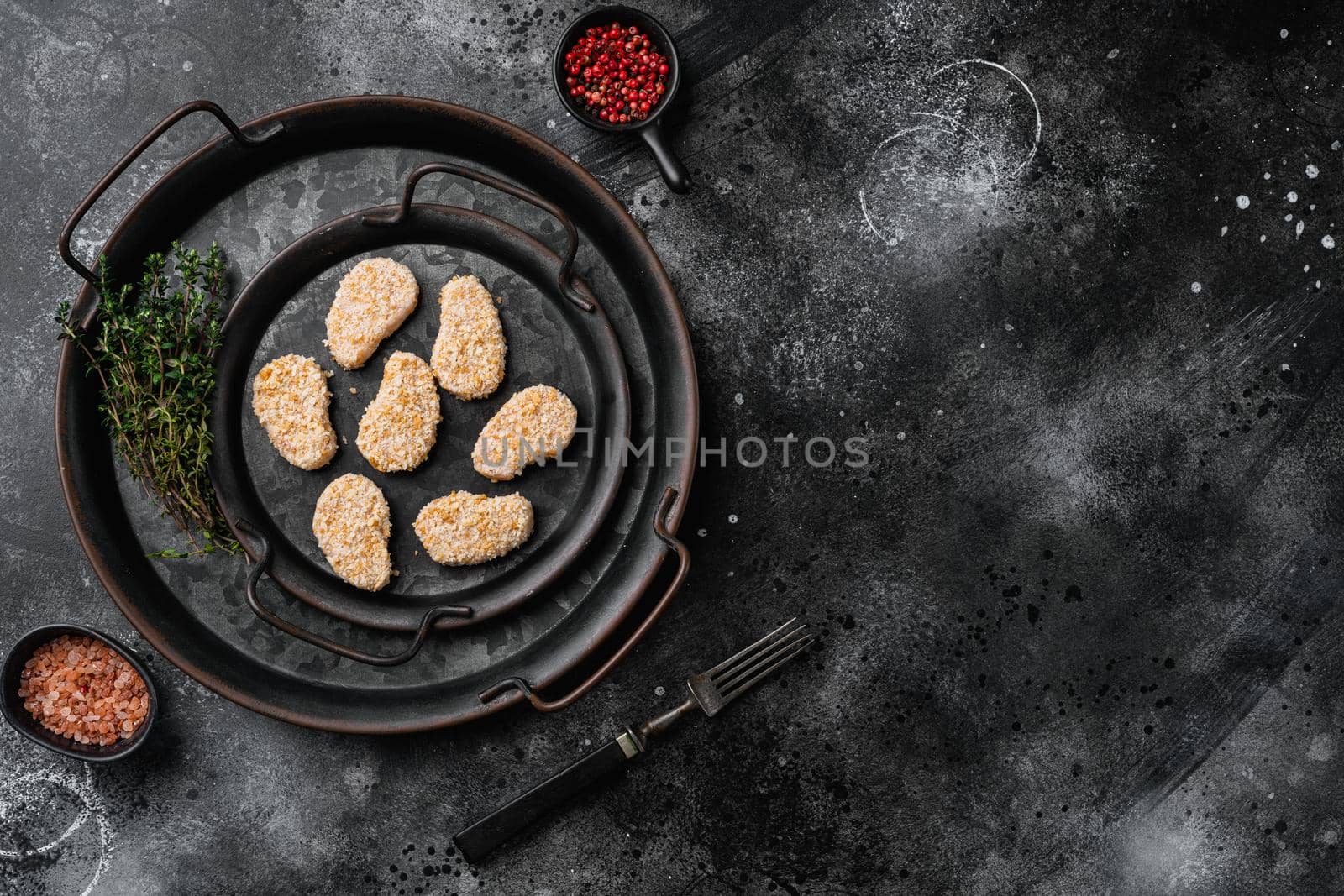 Chicken nuggets uncooked set, on black dark stone table background, top view flat lay, with copy space for text by Ilianesolenyi