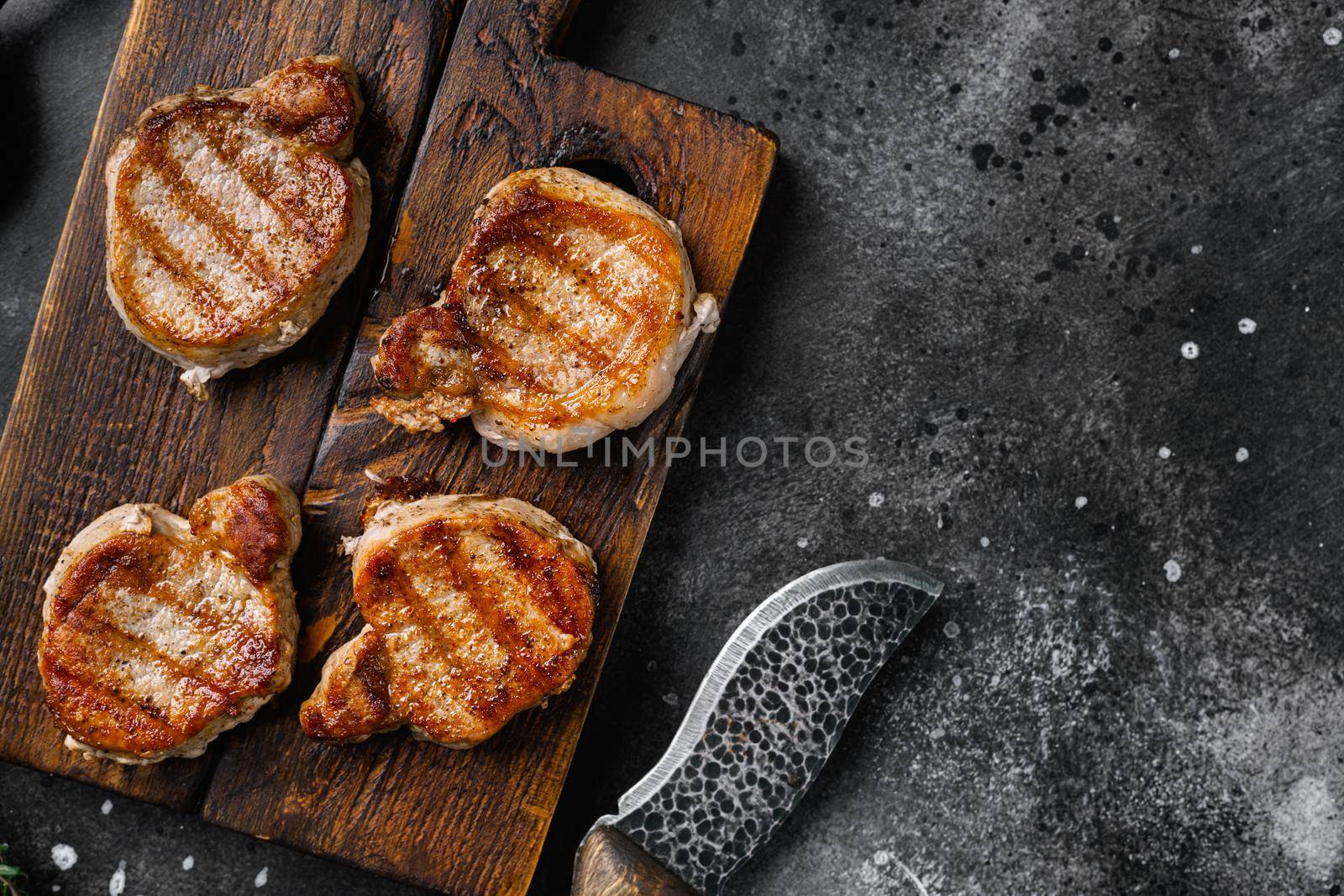 Medallions steaks from pork tenderloin set, on black dark stone table background, top view flat lay, with copy space for text by Ilianesolenyi