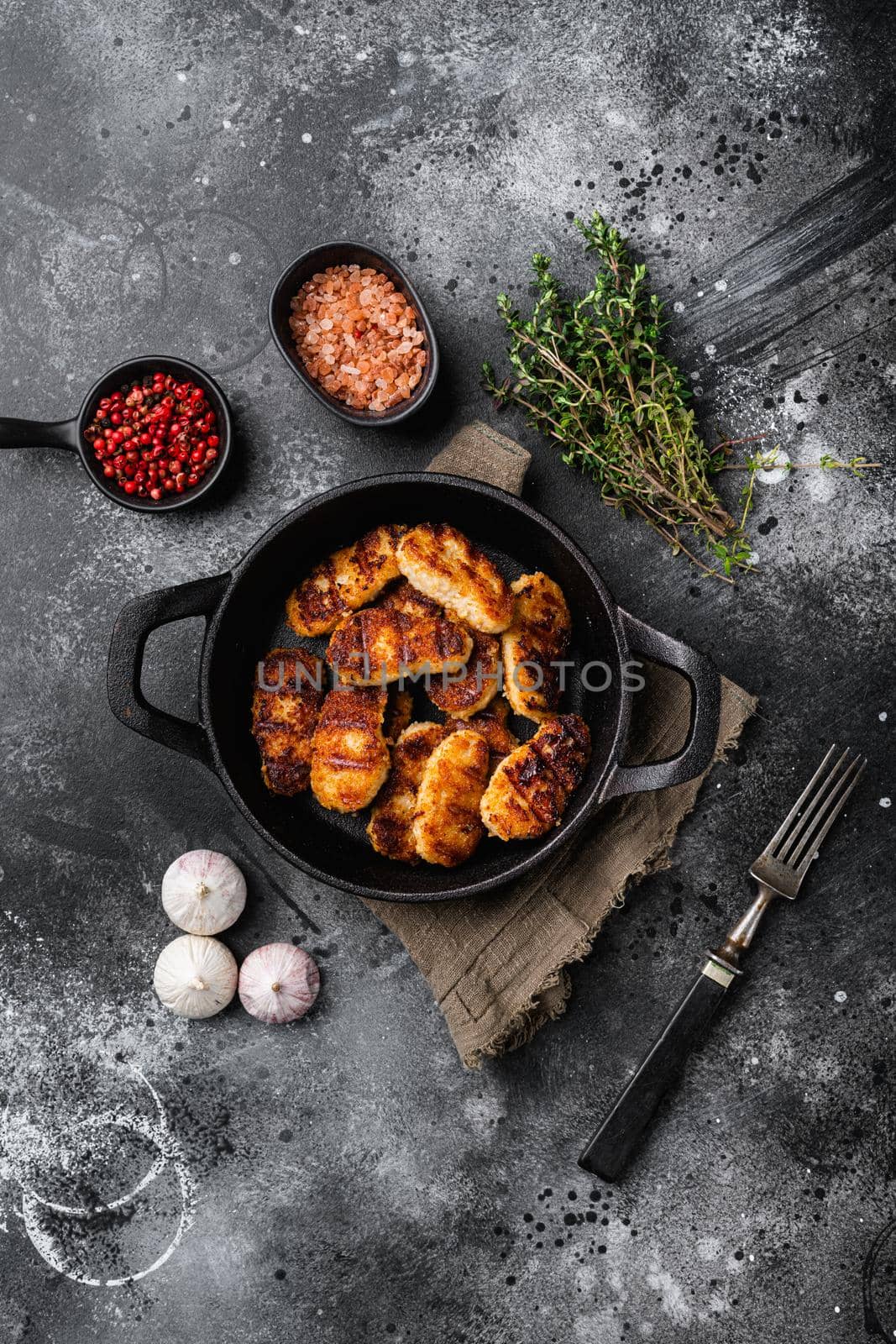 Golden chicken nuggets frying in hot oil, on black dark stone table background, top view flat lay, with copy space for text