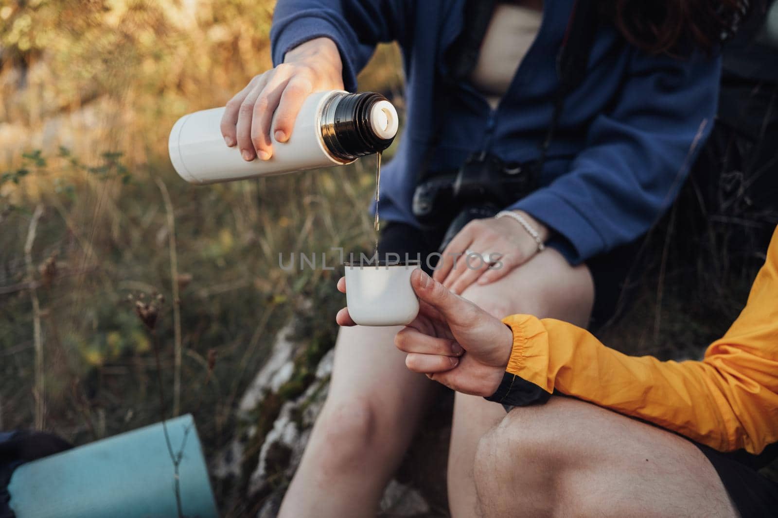 Two Travelers Man and Woman Made a Stop During the Hike to Drink Hot Tea from Thermos