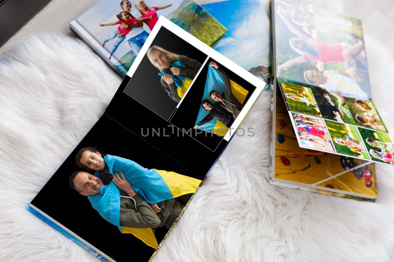 on white table open photobook from photo shoot of family with ukraine flag by Andelov13