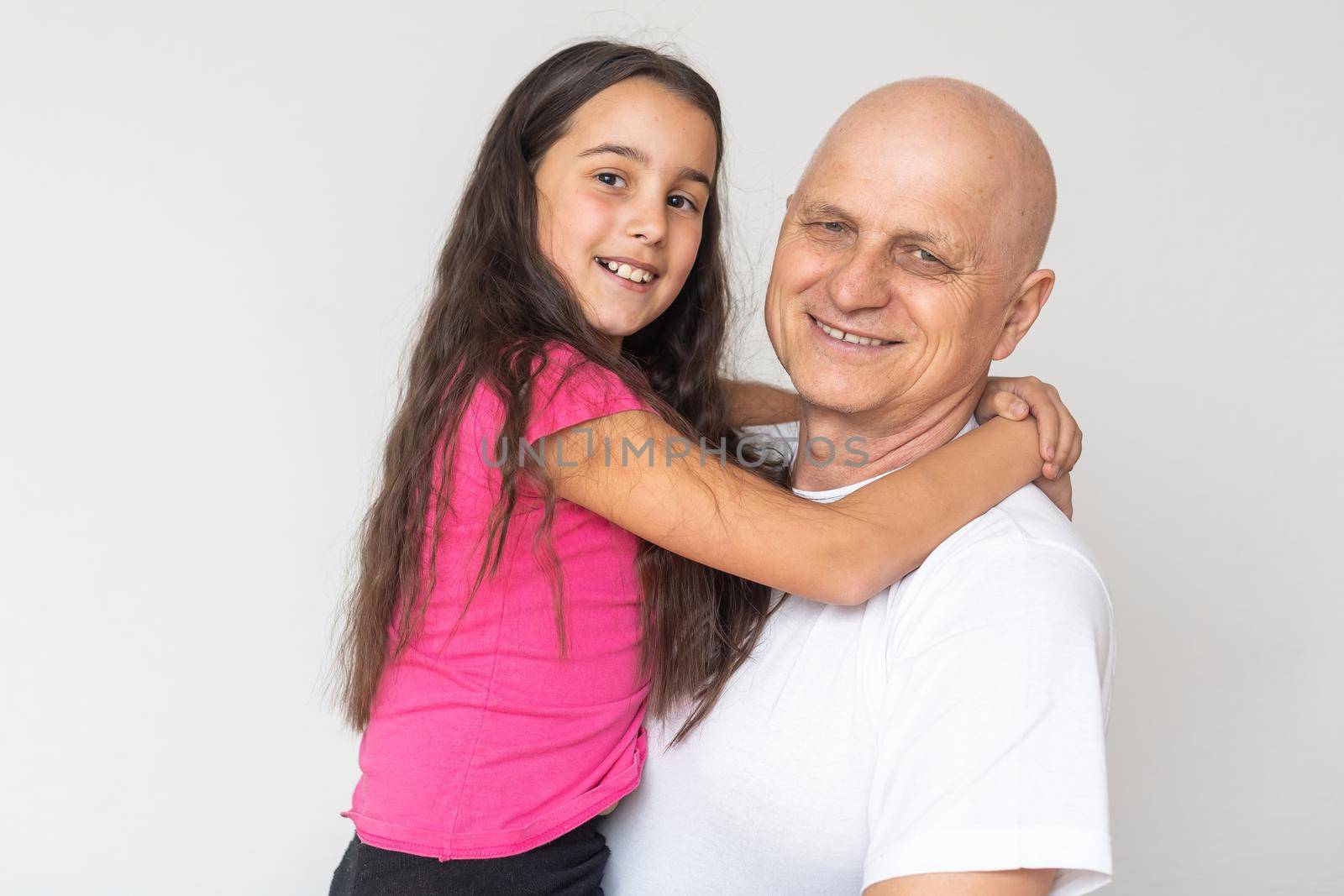 Girl embracing grand father at home. by Andelov13