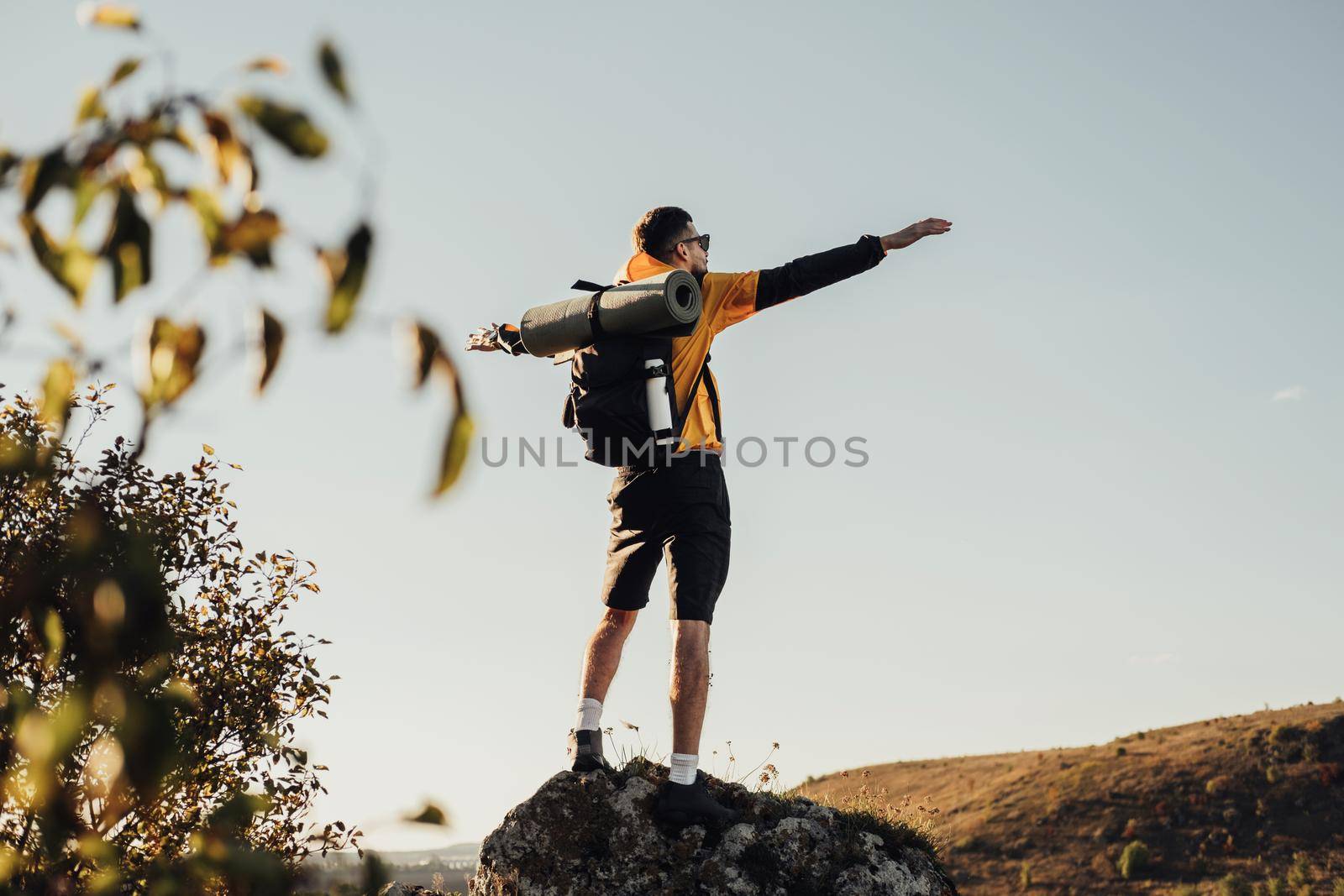 Back View of Travel Man with Backpack, Standing on Top of Rock During Sunset, Male Nomad Enjoy Freedom, Solo Trip Concept