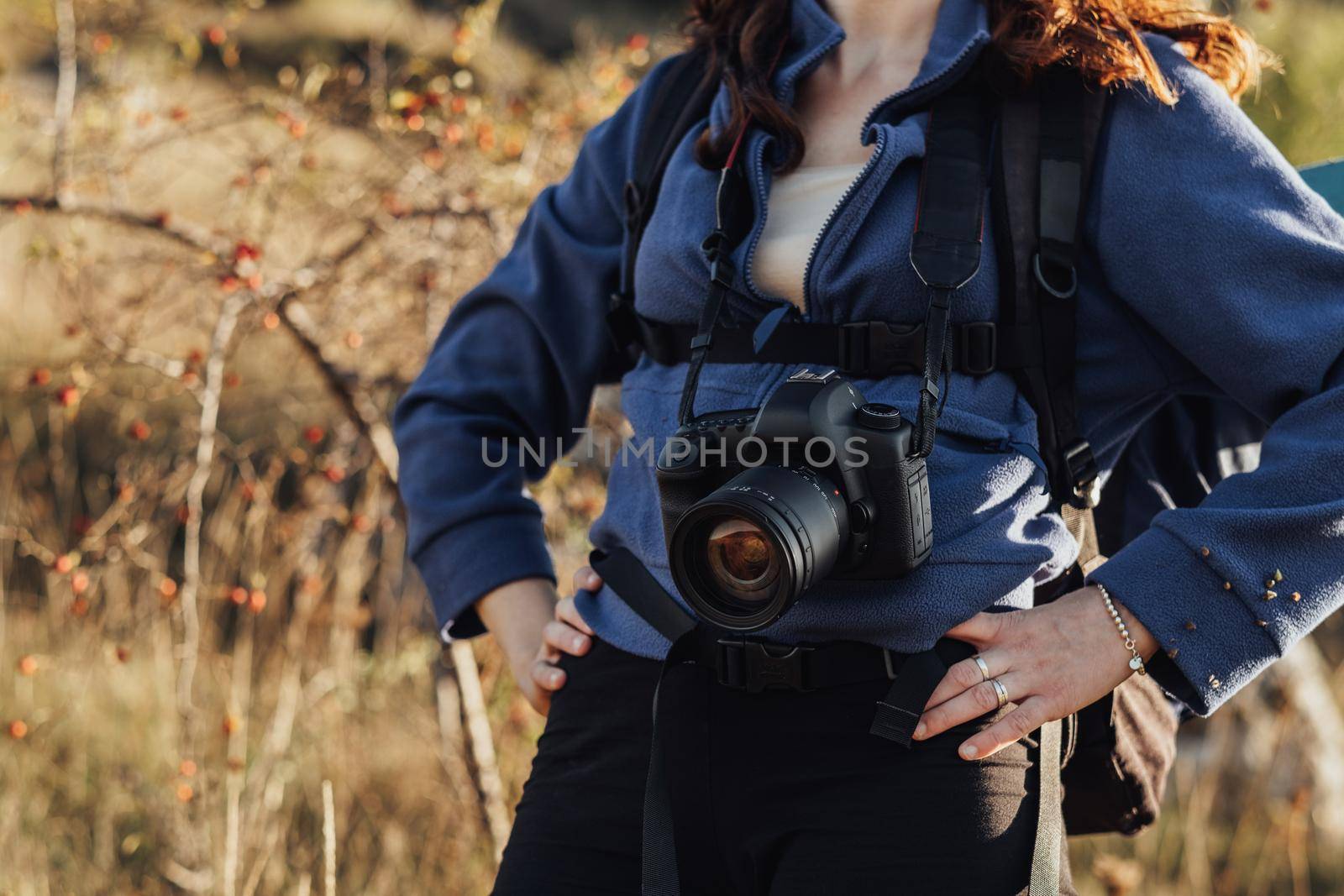 Close Up of Unrecognisable Travel Woman with Backpack and Digital Camera on a Strap Standing on the Route During Her Hike by Romvy