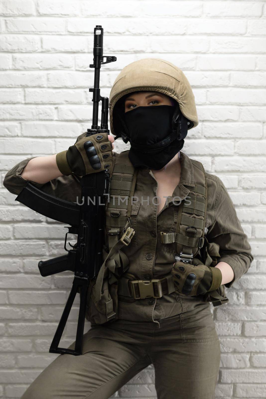 soldier girl in a helmet is sitting and talking on a mobile phone