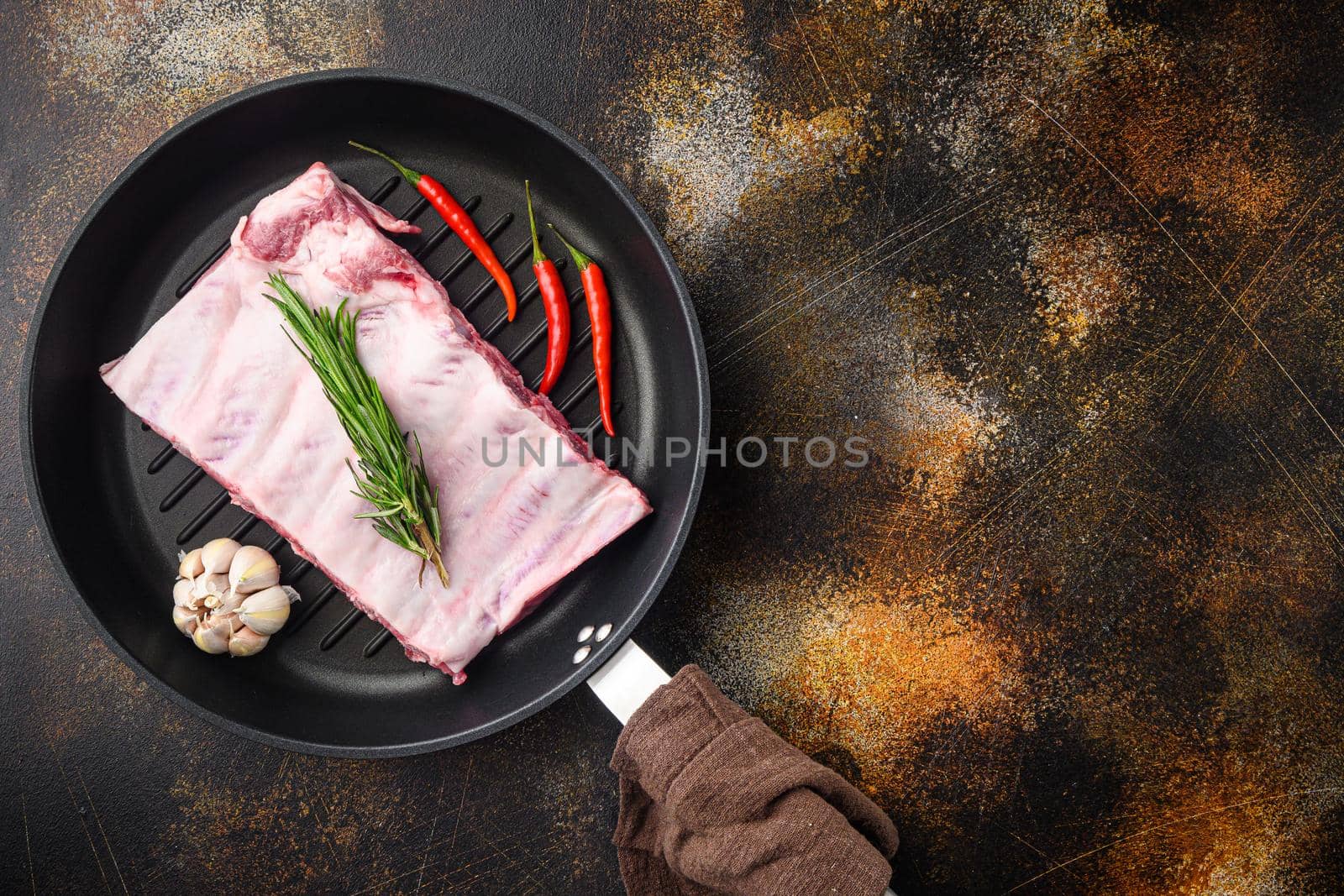 Ribs cooking with sauce marinade ingredient, in cast iron frying pan, top view flat lay, with copy space for text by Ilianesolenyi