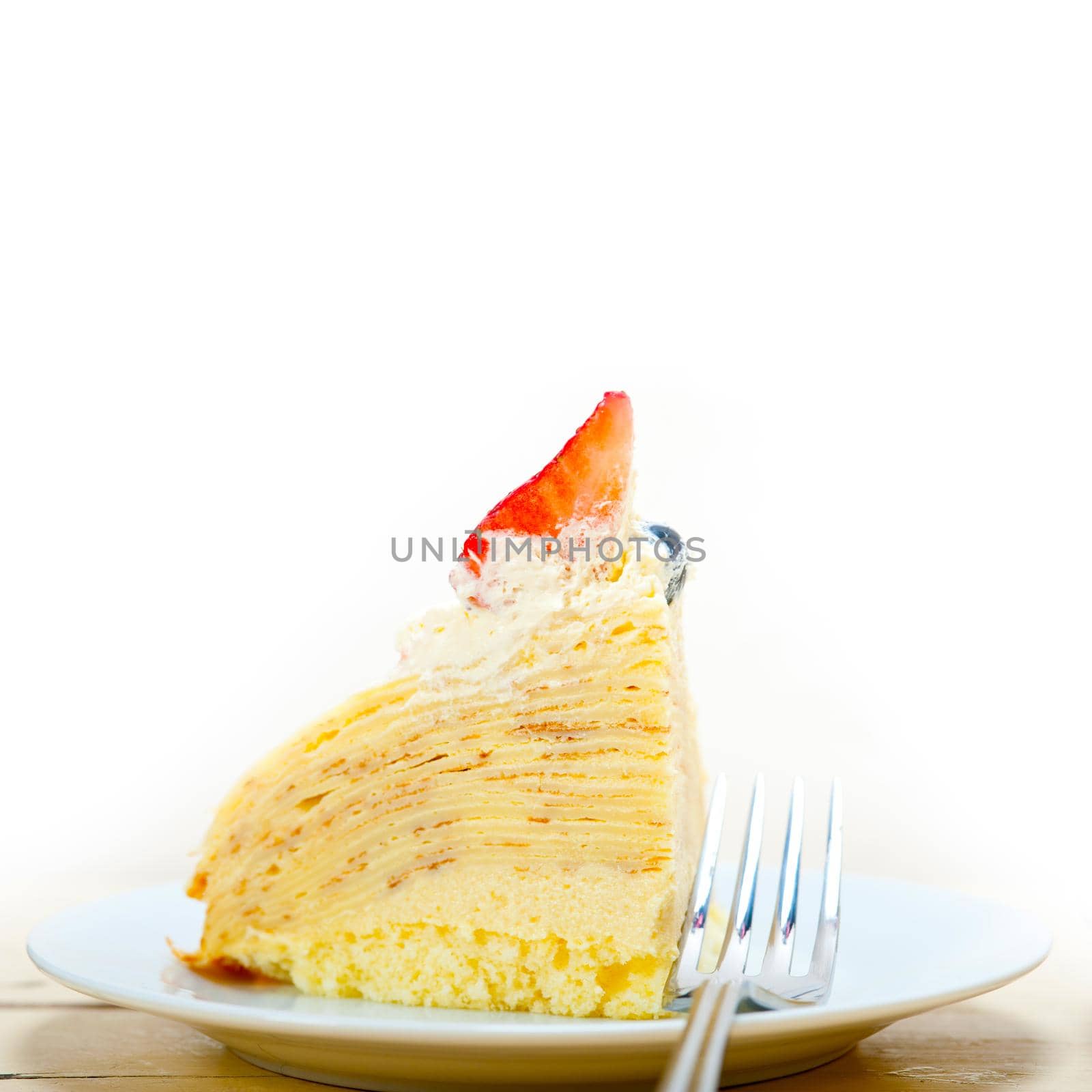 crepe pancake cake with whipped cream and strawberry on top