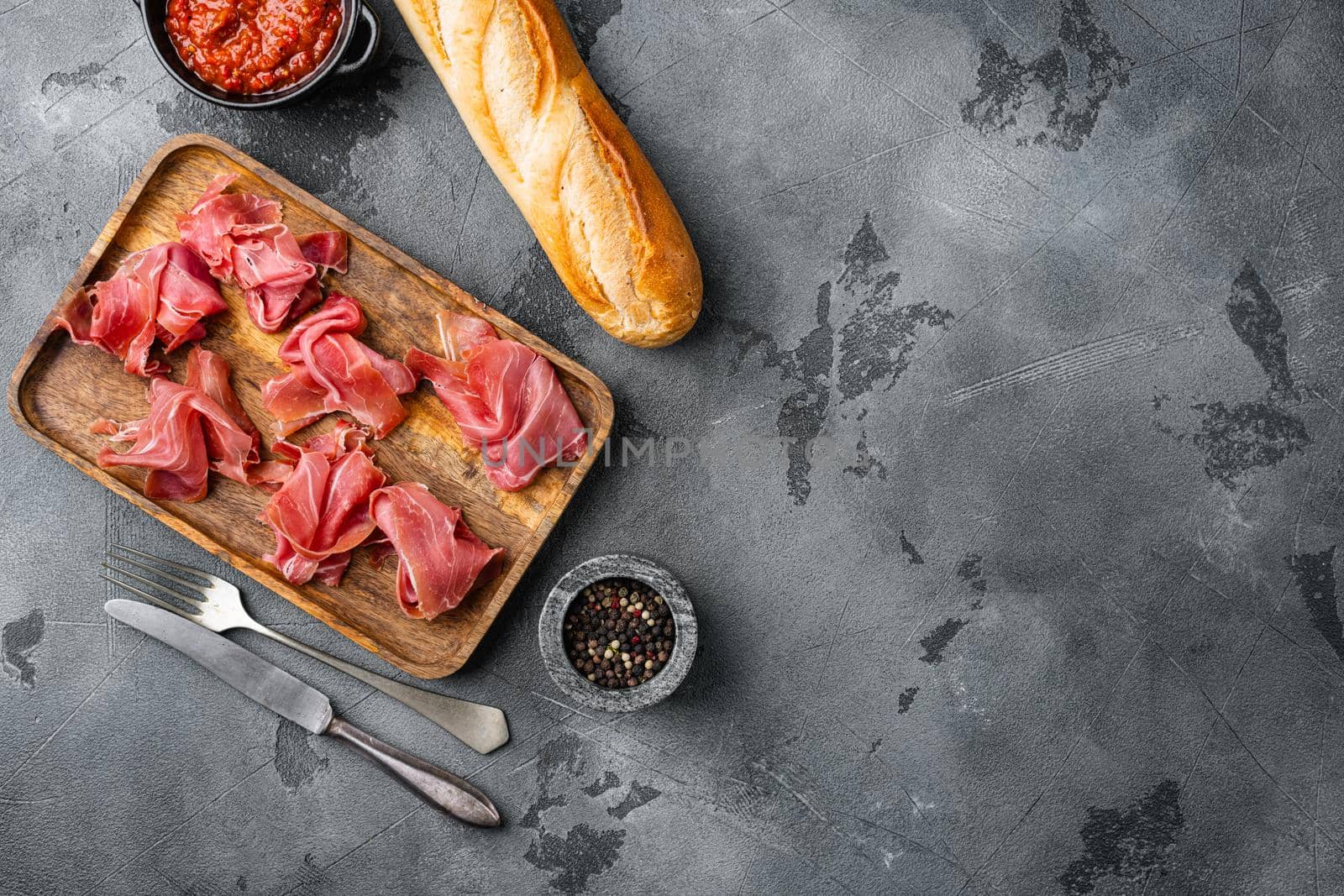 Spanish cold meat jamon set, on gray stone table background, top view flat lay, with copy space for text by Ilianesolenyi