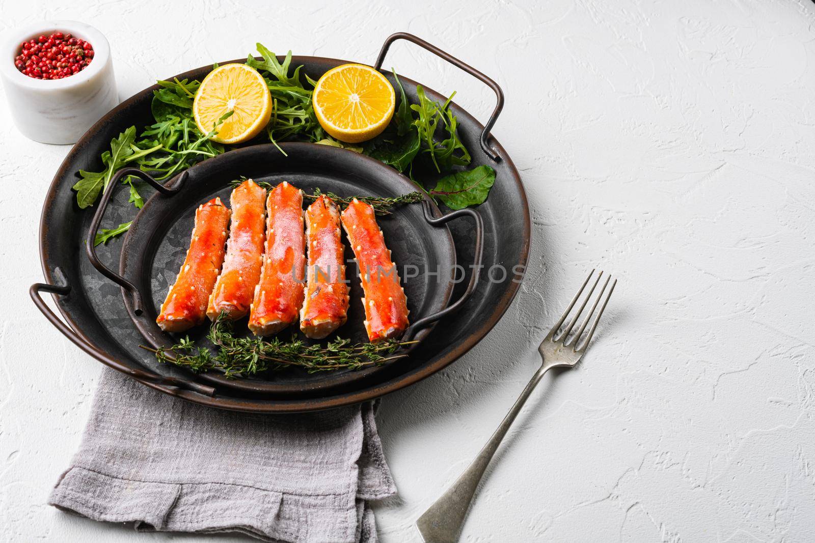 Frozen King crab legs set, on white stone table background, with copy space for text