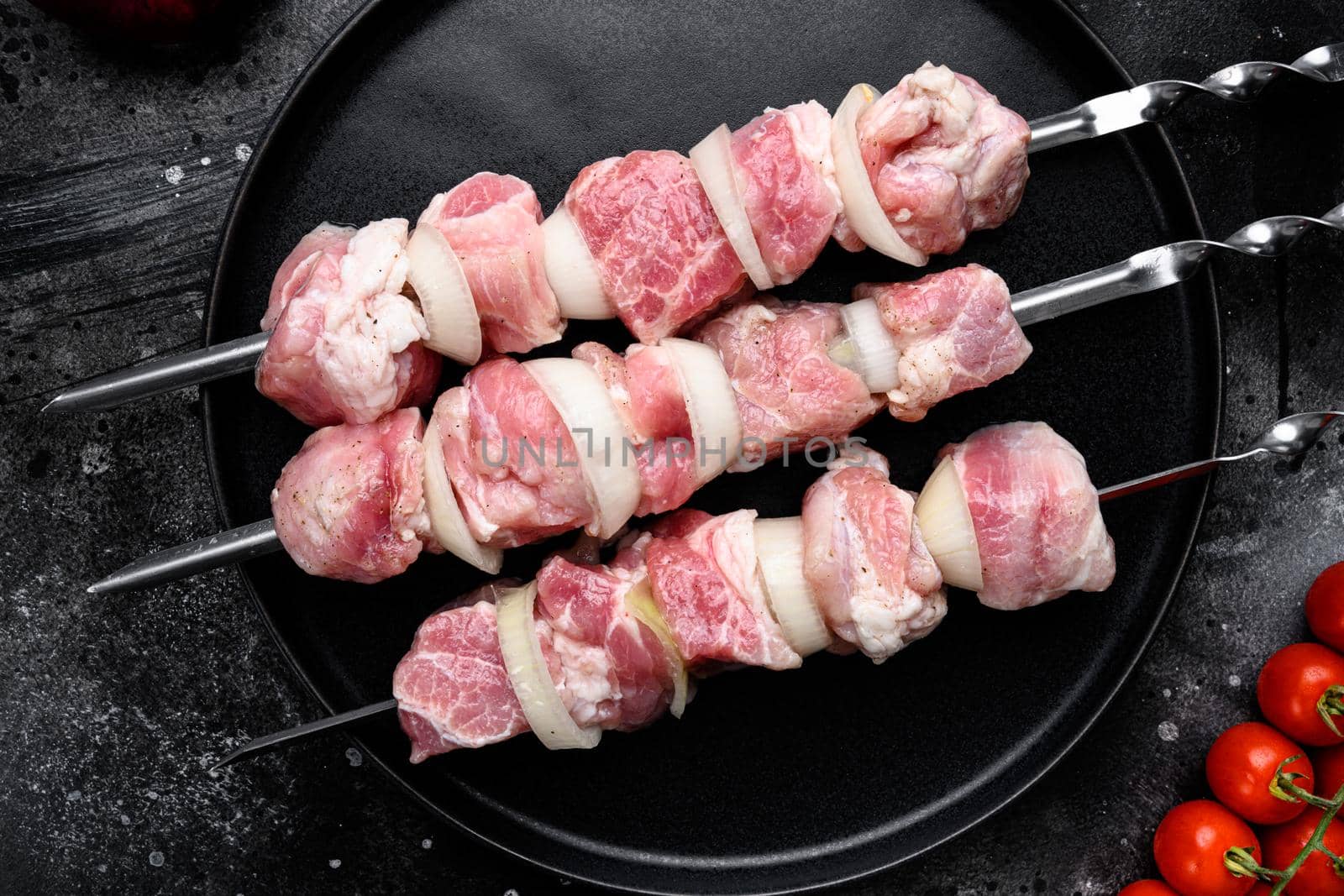 Shish kebab pork meat skewers or shashlik set, top view flat lay, on black dark stone table background