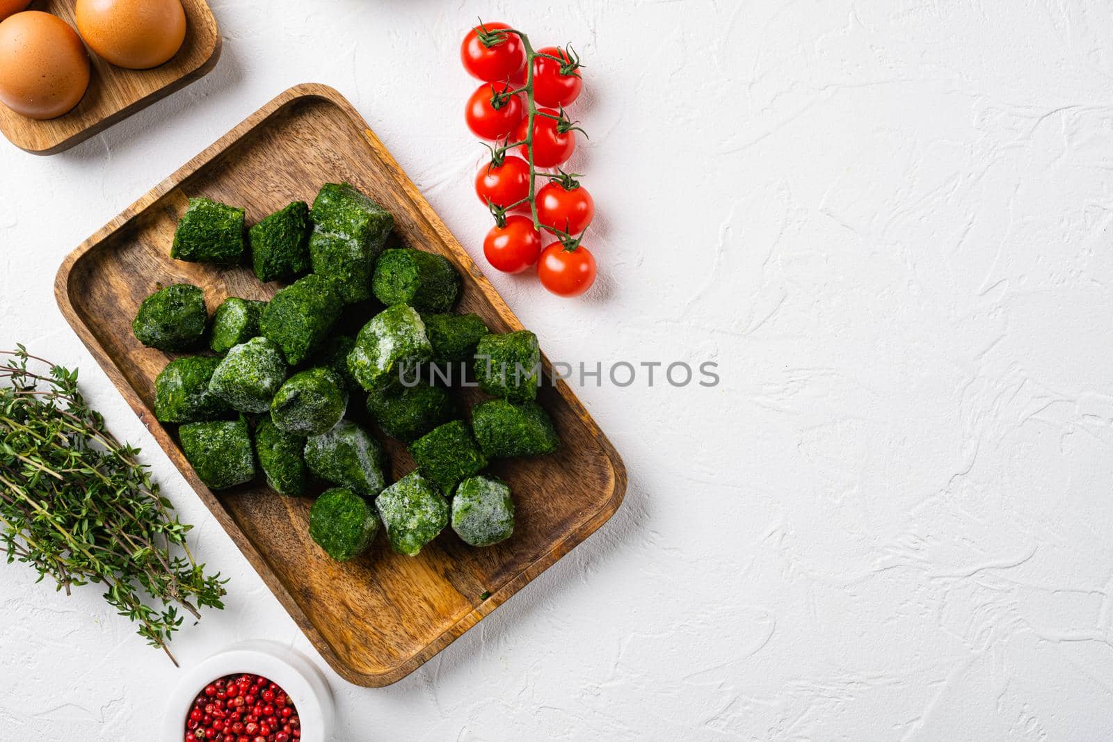 Frozen spinach blocks, on white stone table background, top view flat lay, with copy space for text by Ilianesolenyi