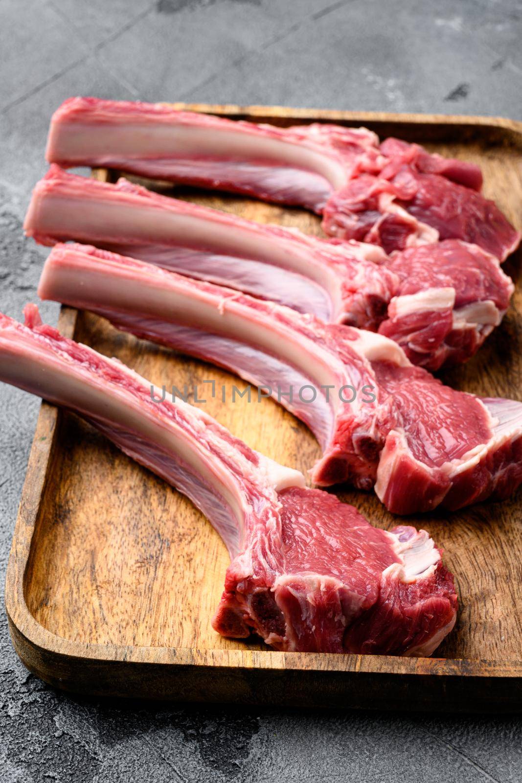 Raw lamb meat chops steaks, on gray stone table background by Ilianesolenyi