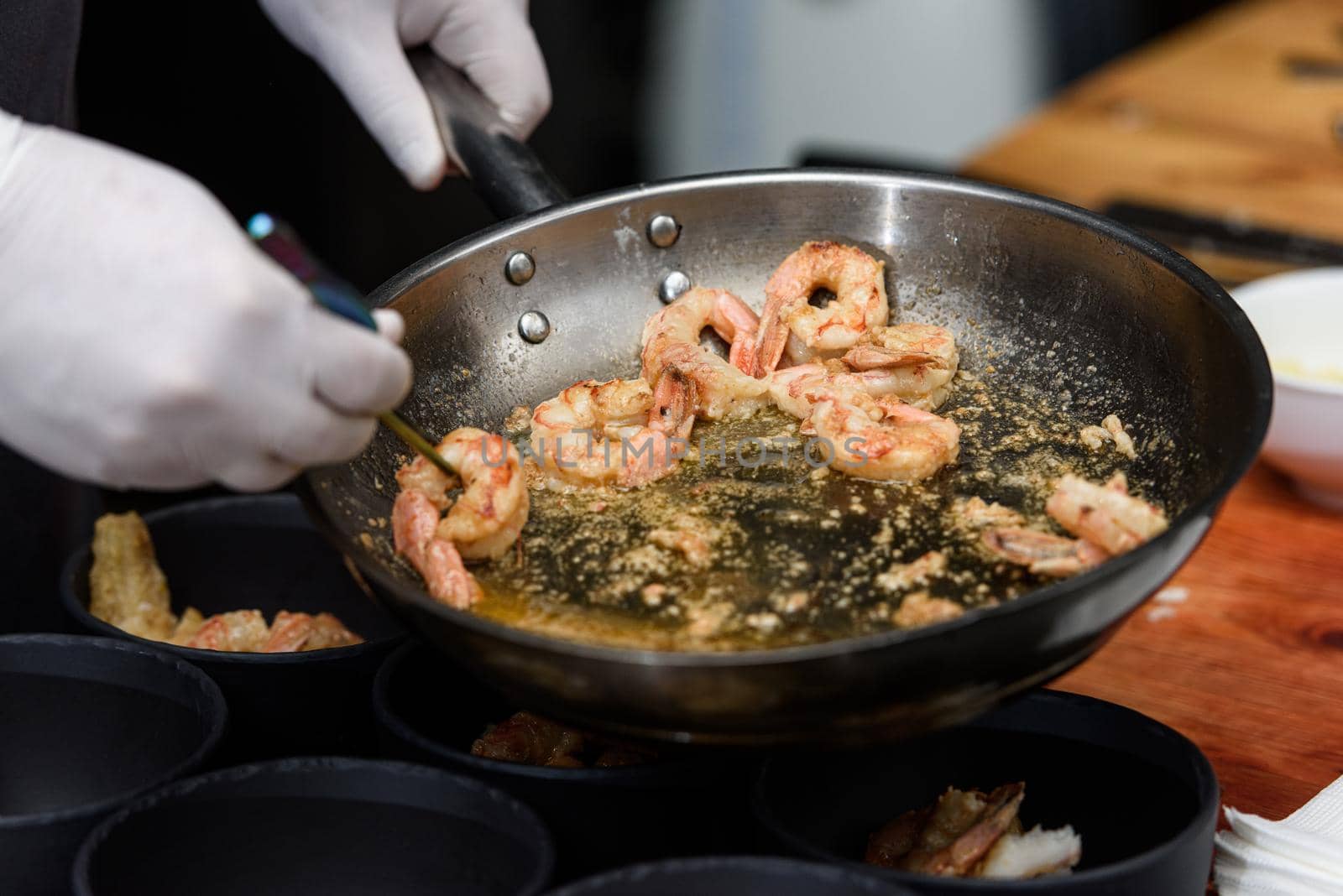 cooking process of Suquet de Peix soup with potatoes, herbs and fish with the addition of picada close-up in a saucepan on the table. horizontal