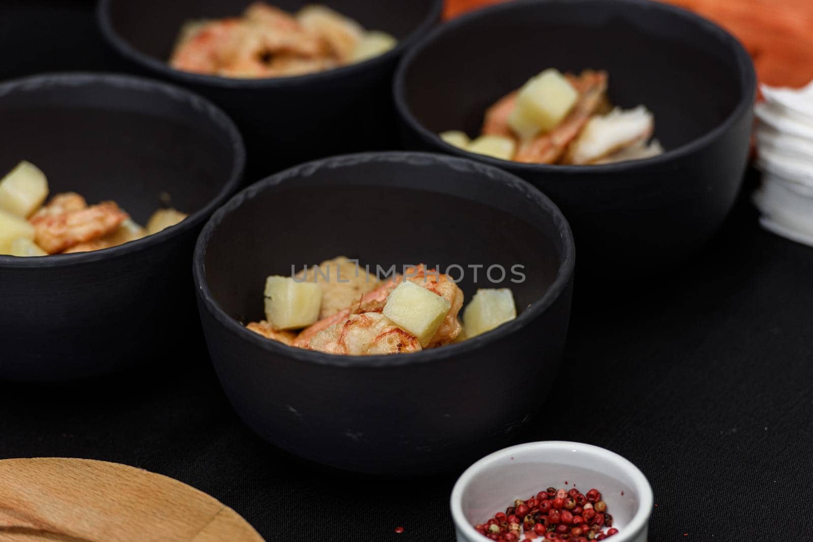 cooking process of Suquet de Peix soup with potatoes, herbs and fish with the addition of picada close-up in a saucepan on the table. horizontal