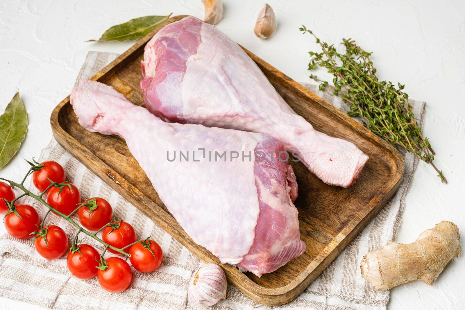 Fresh uncooked turkey legs, on white stone table background by Ilianesolenyi