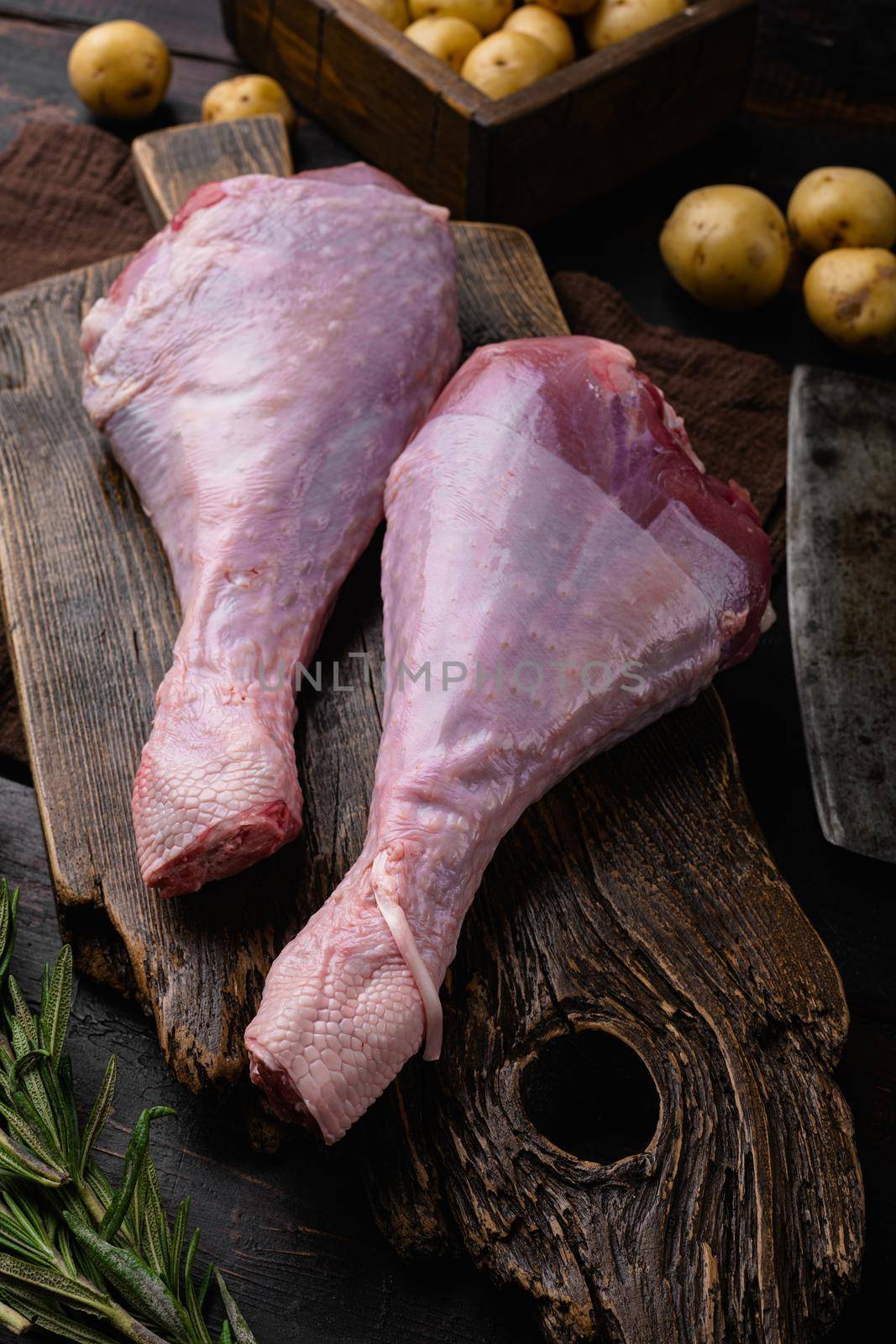 Fresh turkey legs with ingredients for cooking, on old dark wooden table background by Ilianesolenyi