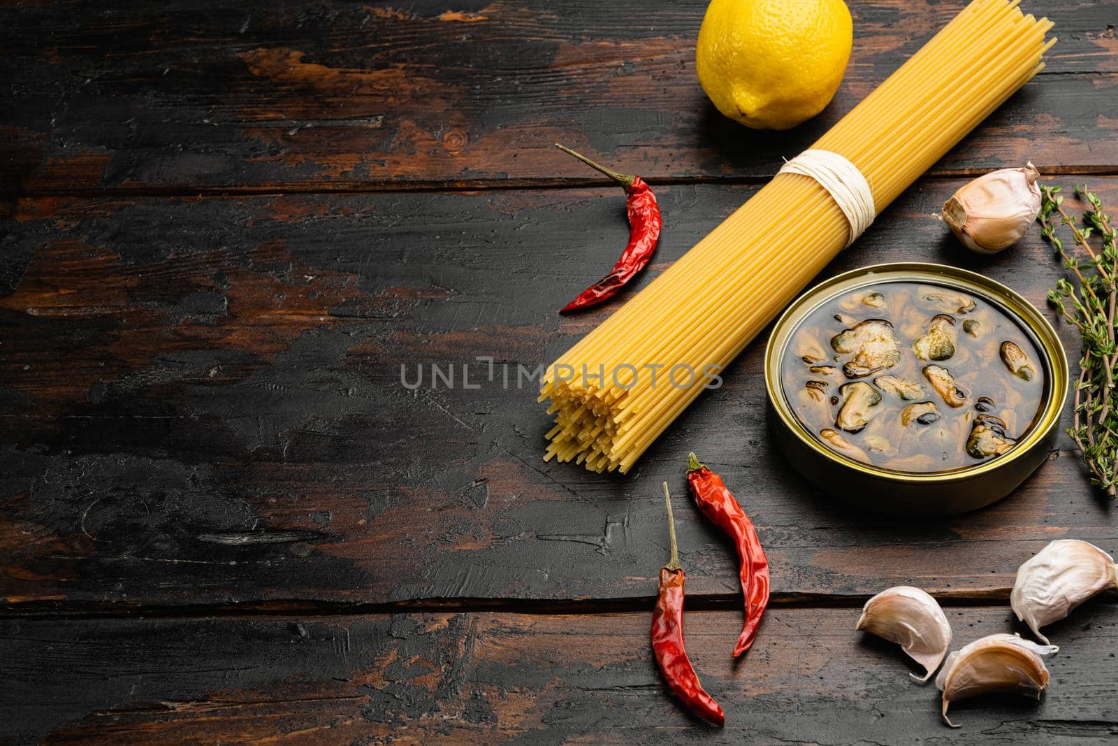 Raw Pasta with cream sauce, mussels and parmesan ingredients set, on old dark wooden table background, with copy space for text