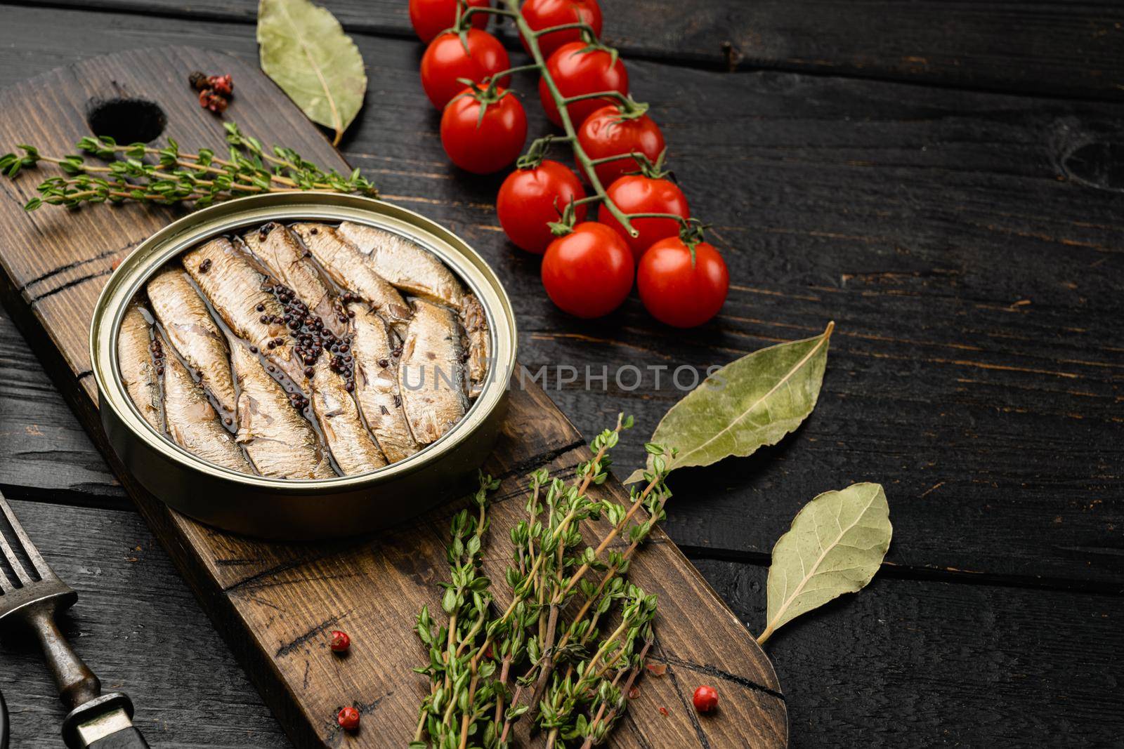 Open can of sardines, on black wooden table background, with copy space for text by Ilianesolenyi