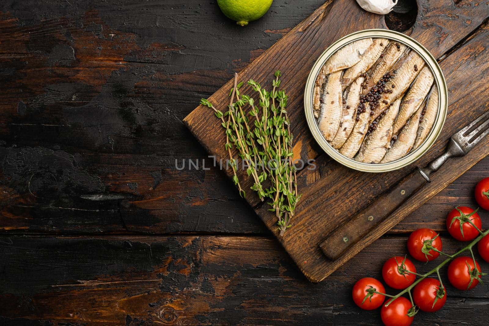 Smoked fish with olive oil set, on old dark wooden table background, top view flat lay, with copy space for text