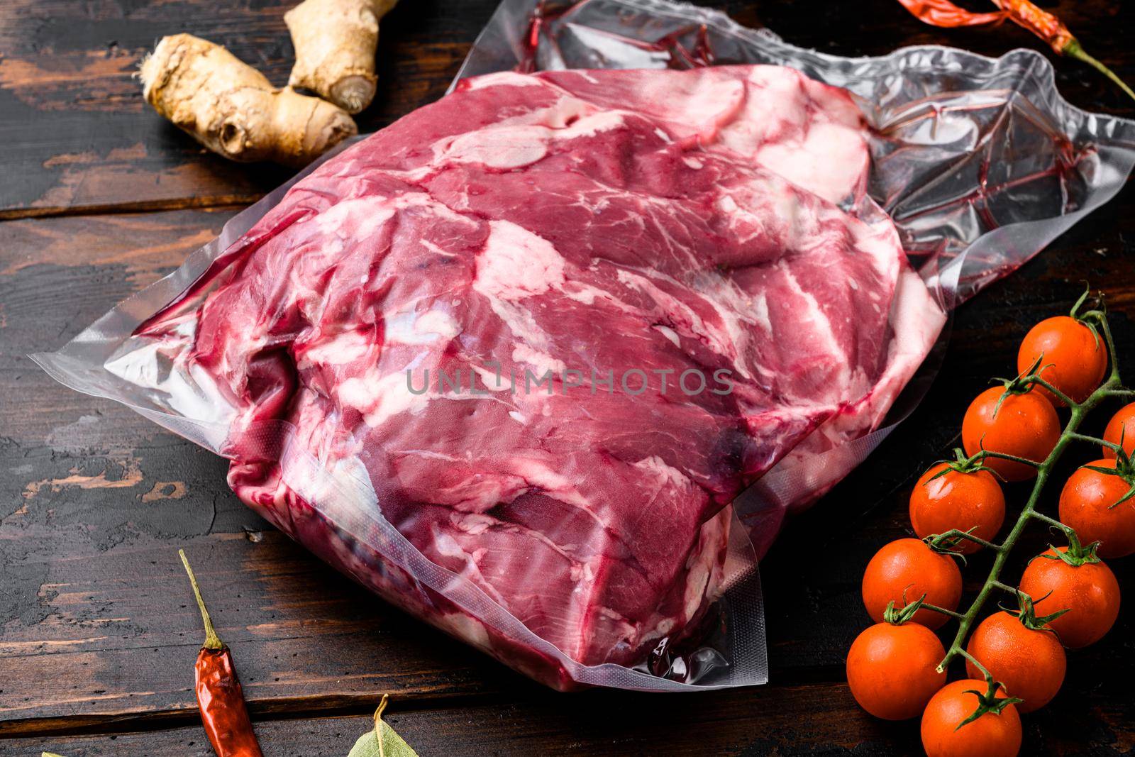 Lamb meat raw pack set, with ingredients and herbs, on old dark wooden table background