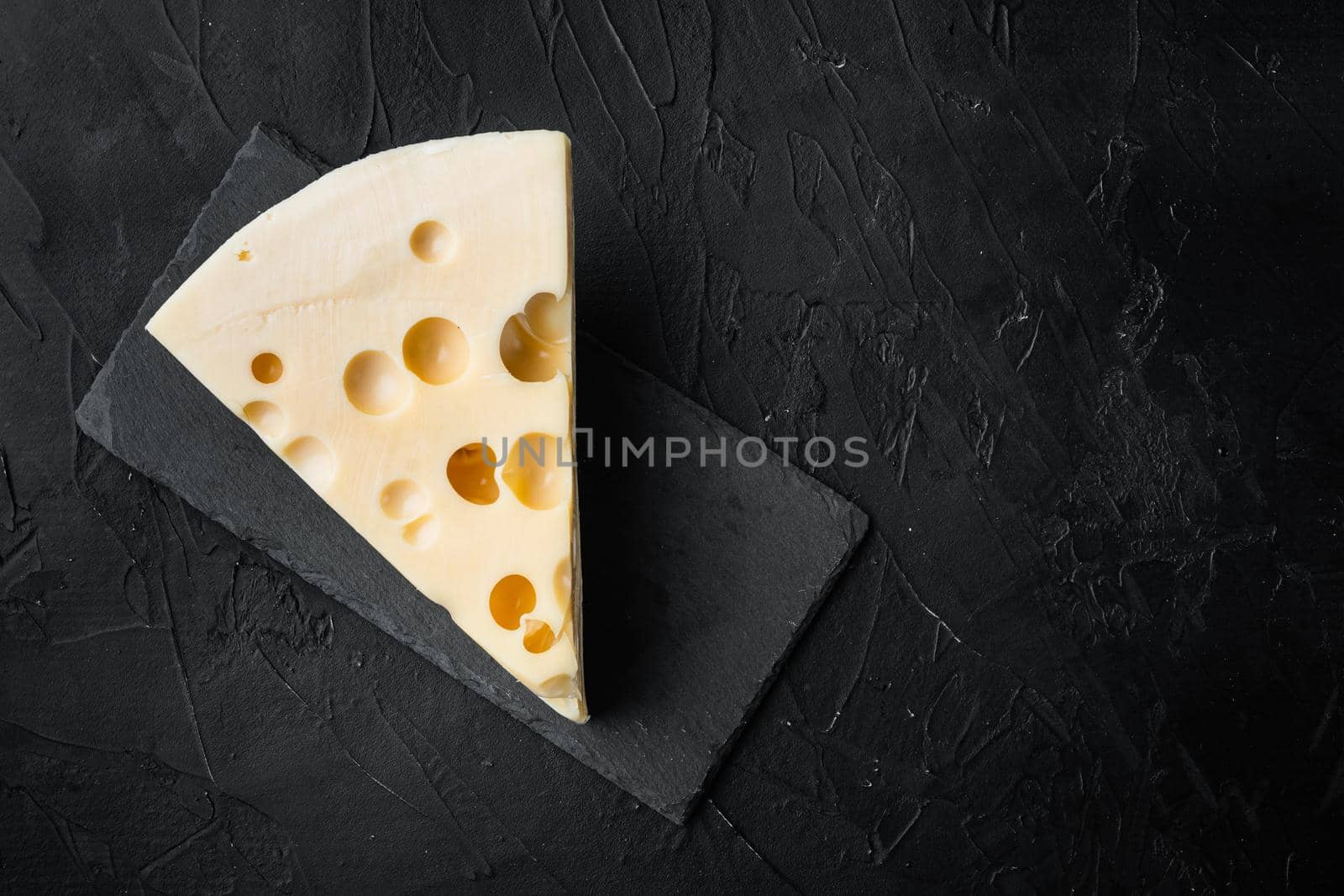 Maasdam cheese set, on black stone background, top view flat lay, with copy space for text