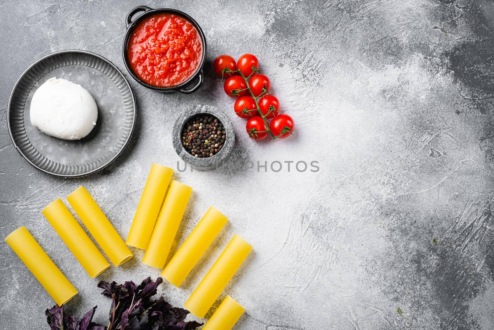 Cannelloni with spinach and ricotta set, on gray stone table background, top view flat lay, with copy space for text