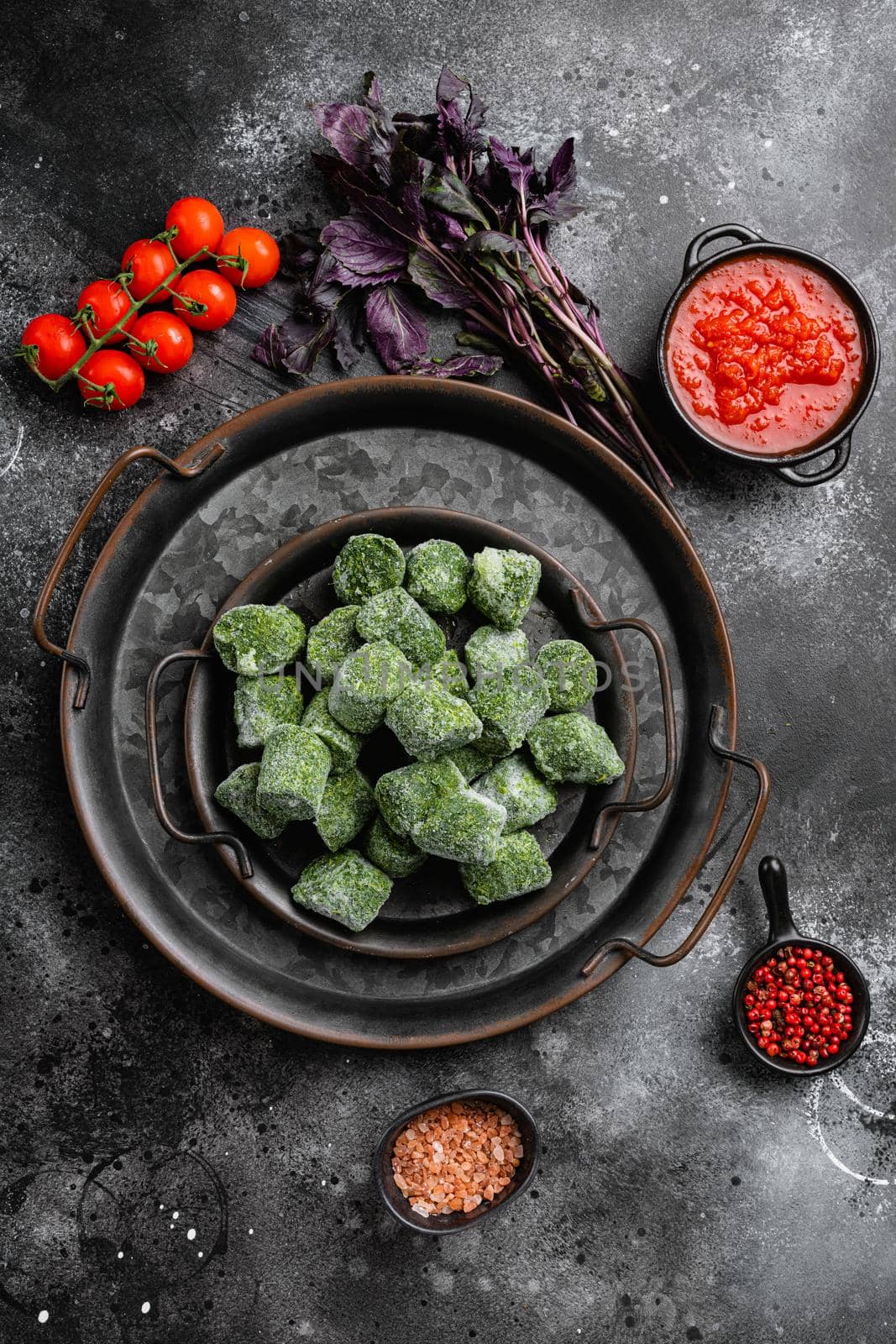 Frozen spinach cubes, on black dark stone table background, top view flat lay, with copy space for text by Ilianesolenyi