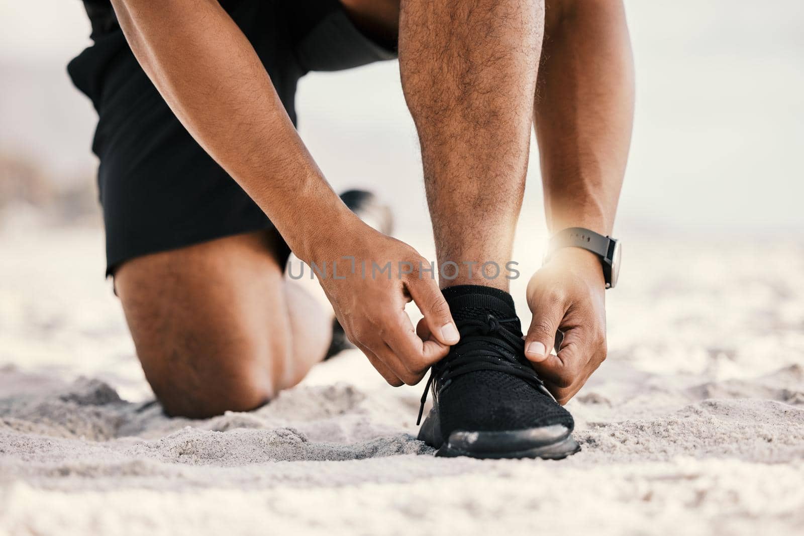 I talk the talk and I run the run. Cropped shot of an unrecognizable man tying his shoelaces while out for a workout. by YuriArcurs