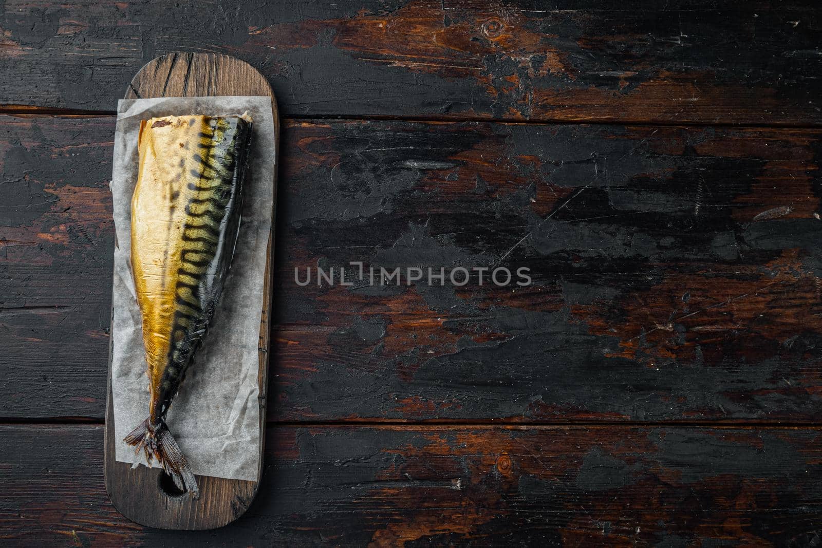 Smoked mackerel, on old dark wooden table background, top view flat lay with copy space for text by Ilianesolenyi