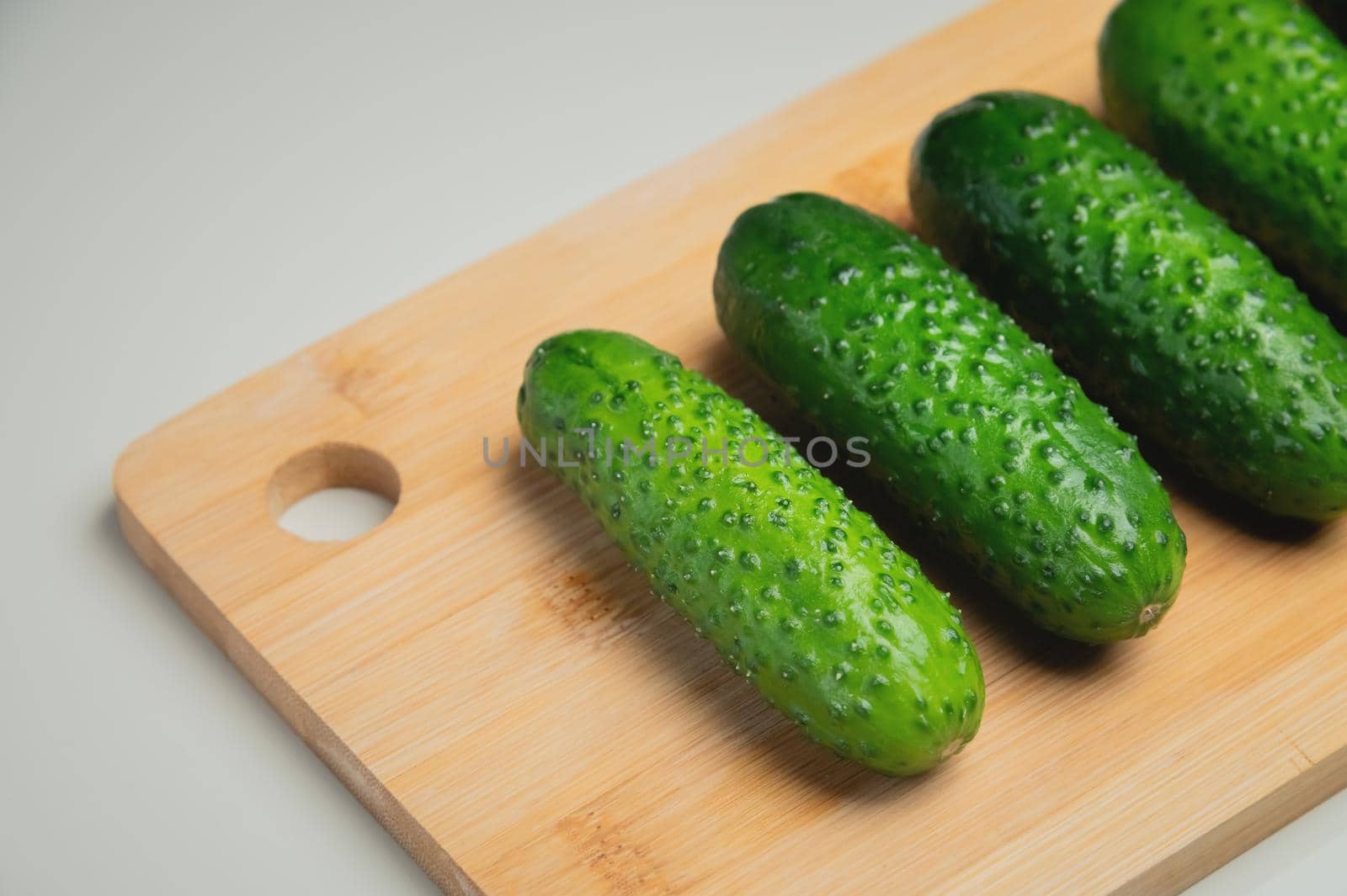 juicy ripe cucumber in half lies on a wooden cutting board. top view, shooting on the table.