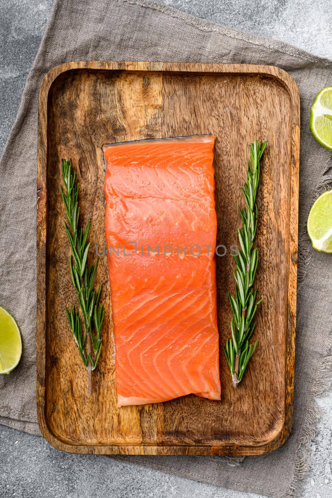 Fresh salmon steak, with herbs, on gray stone table background, top view flat lay by Ilianesolenyi