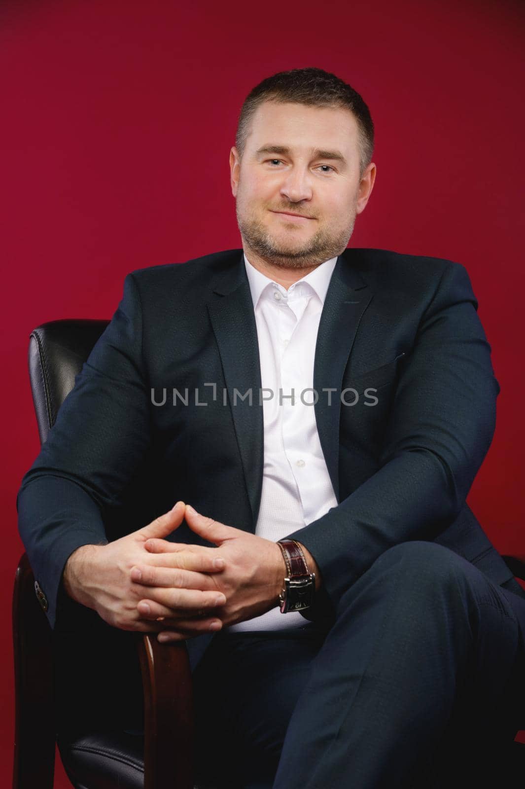 Happy divorced man touching the ring on the ring finger of his right hand Portrait of a handsome man in an elegant suit on a red background. Studio shot. by yanik88