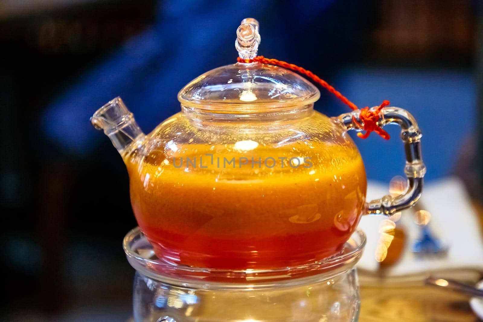 Red tea with sea buckthorn in a glass teapot. by Milanchikov