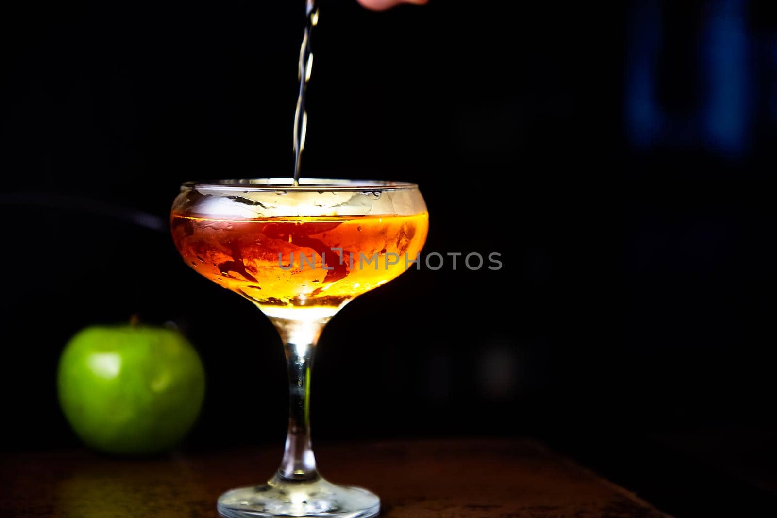 Red cocktail with lemon slice and Apple