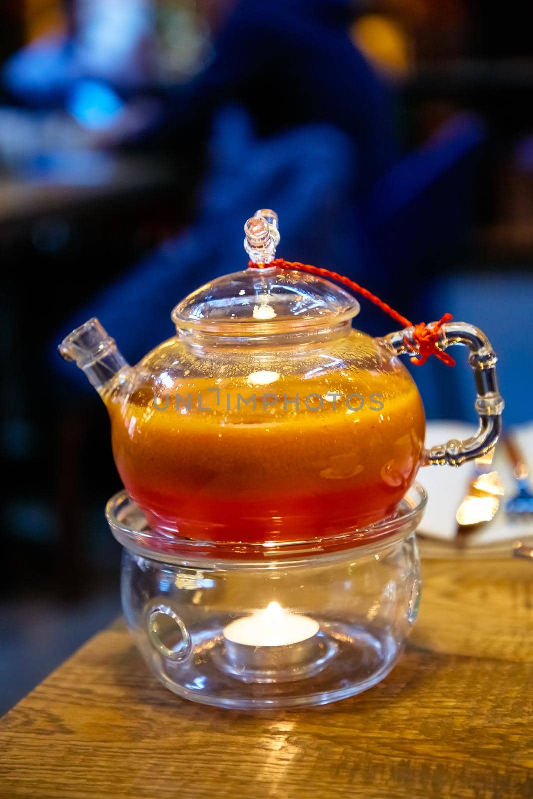 Red tea with sea buckthorn in a glass teapot.