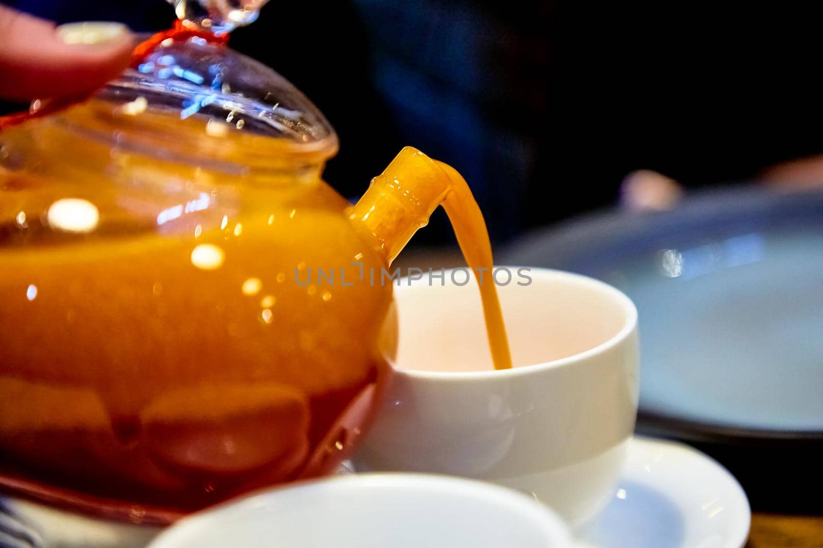 Red tea with sea buckthorn in a glass teapot. by Milanchikov
