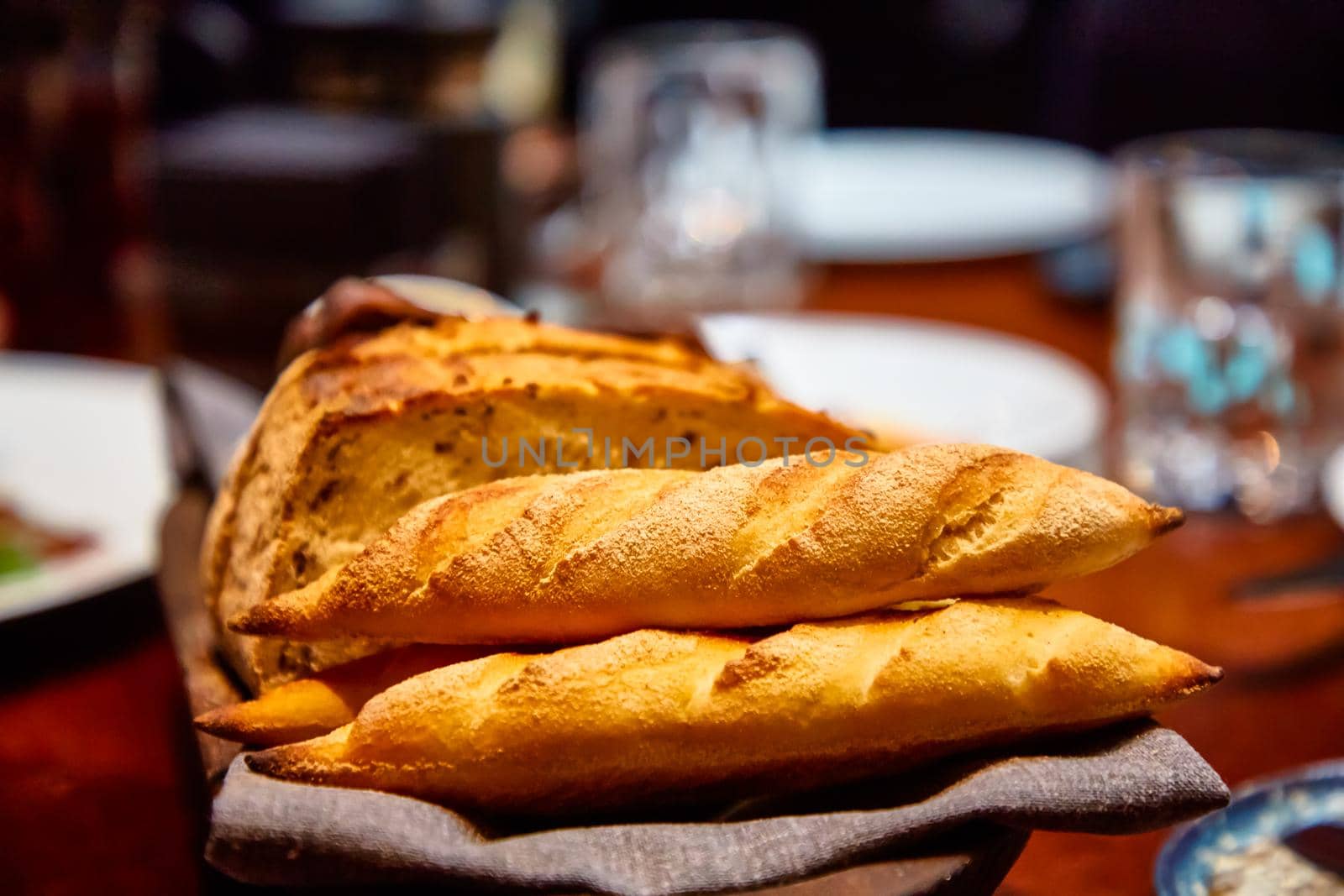 Basket with different bread on the table in the restaurant by Milanchikov