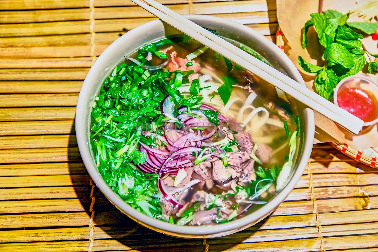 Traditional Vietnamese soup, Pho Bo in a large bowl. by Milanchikov