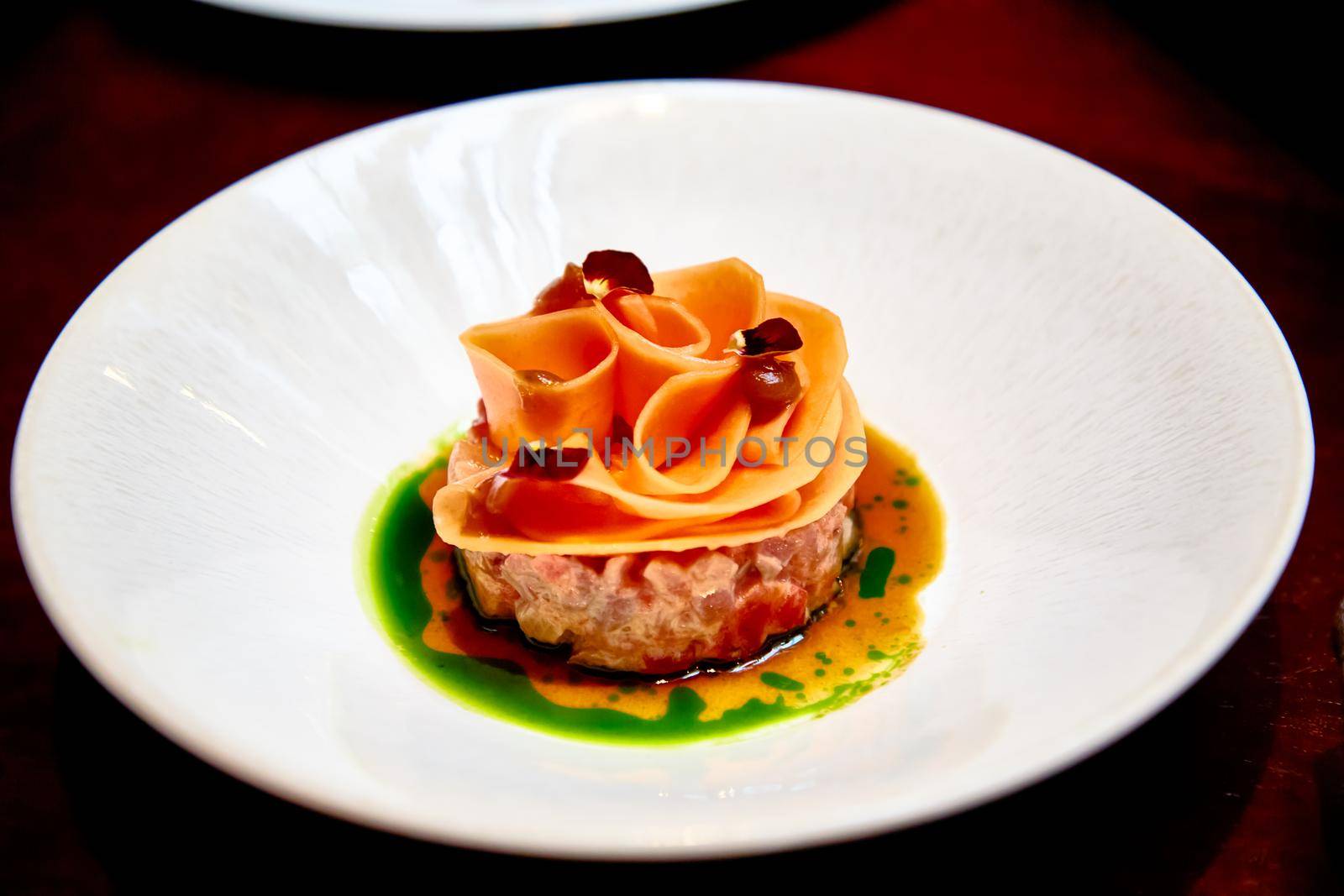 Beef tartare decorated with carrot slices by Milanchikov