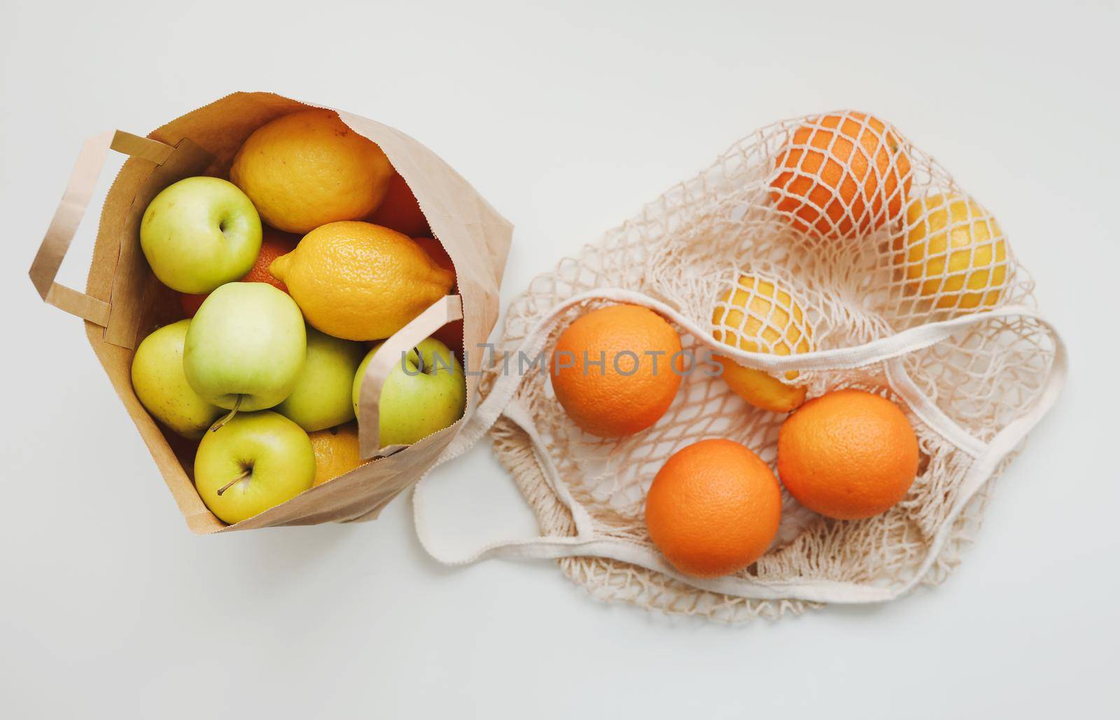 Lemons in reusable bag. Zero waste concept with string bag, mesh bag, grosery bag with fruits on white background, flat lay, top view, copy space.