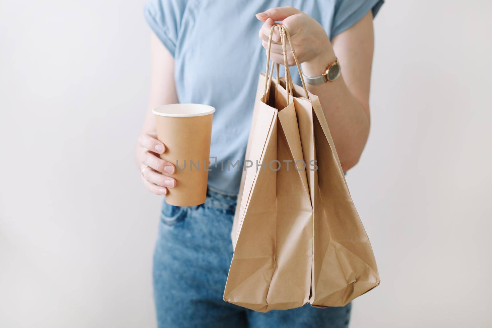 Delivery concept background. Woman hands holding craft paper bags on white, copy space, banner, close-up.