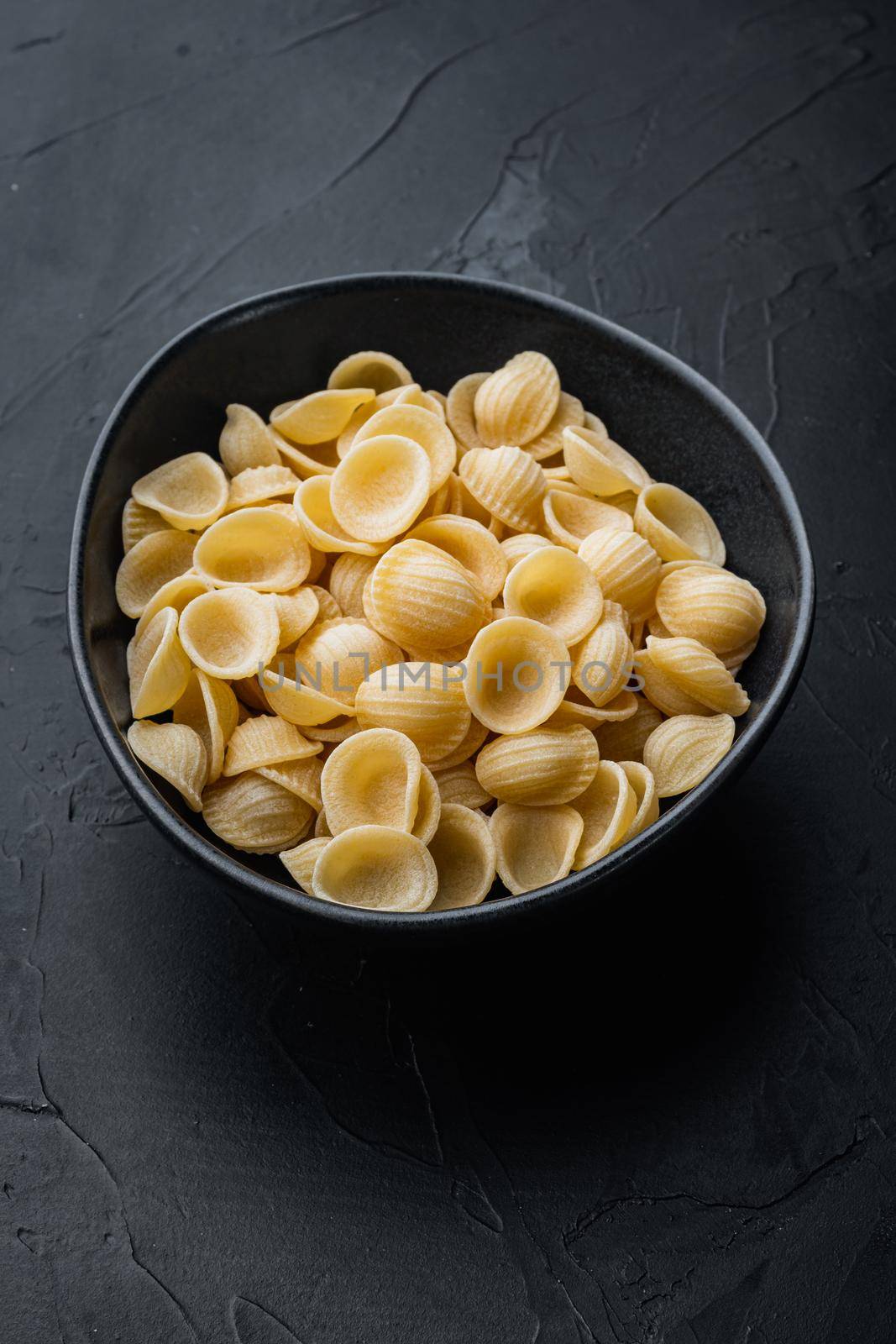 Semolina pasta, on black background by Ilianesolenyi