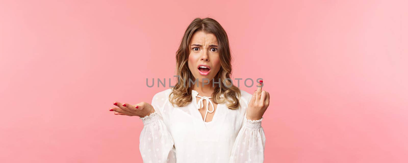 Close-up portrait of questioned and annoyed young woman tired of waiting for boyfriend making next step and do proposal, showing finger without ring, shrugging and complaining.