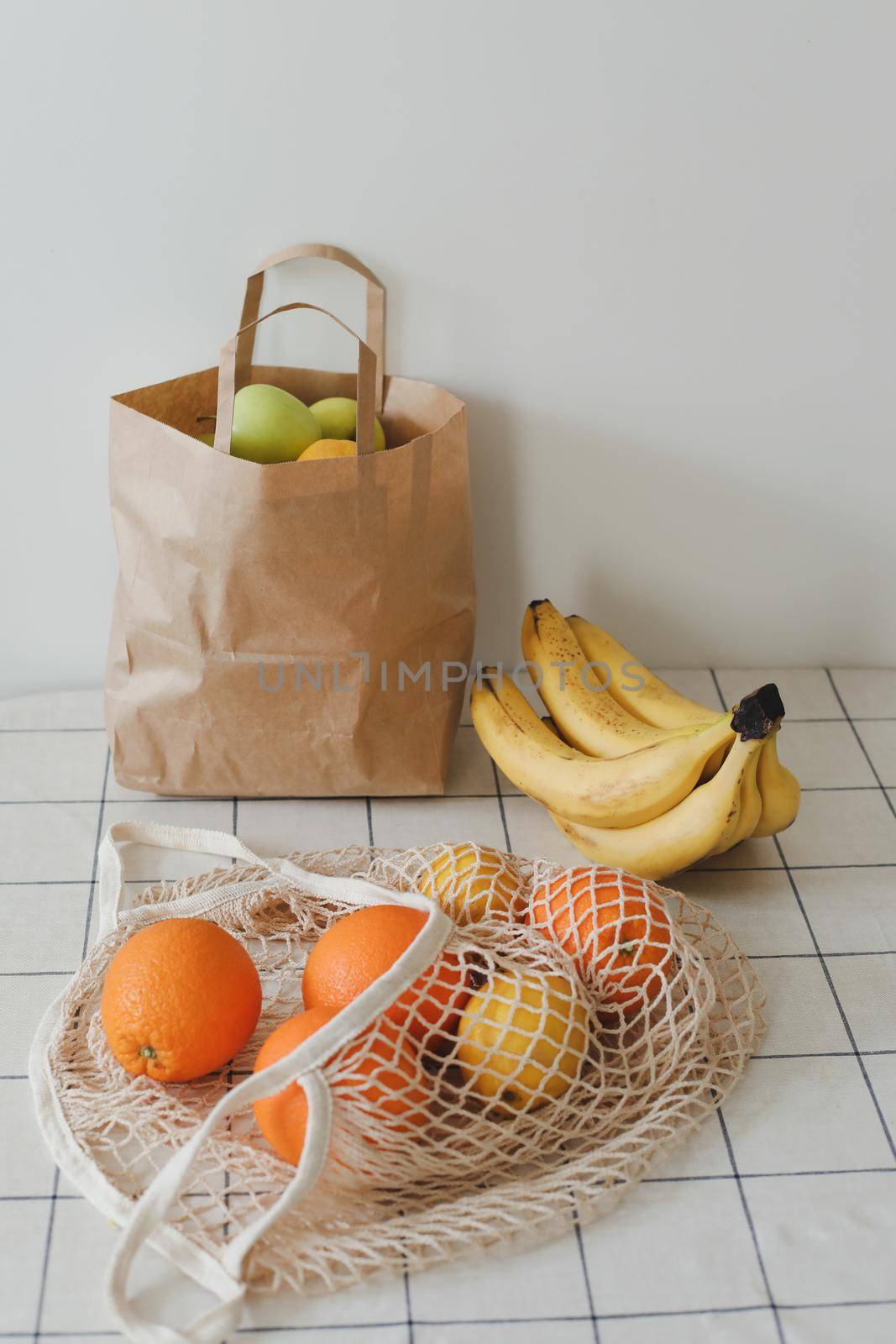 Lemons in reusable bag. Zero waste concept with string bag, mesh bag, grosery bag with fruits on white background, flat lay, top view, copy space.