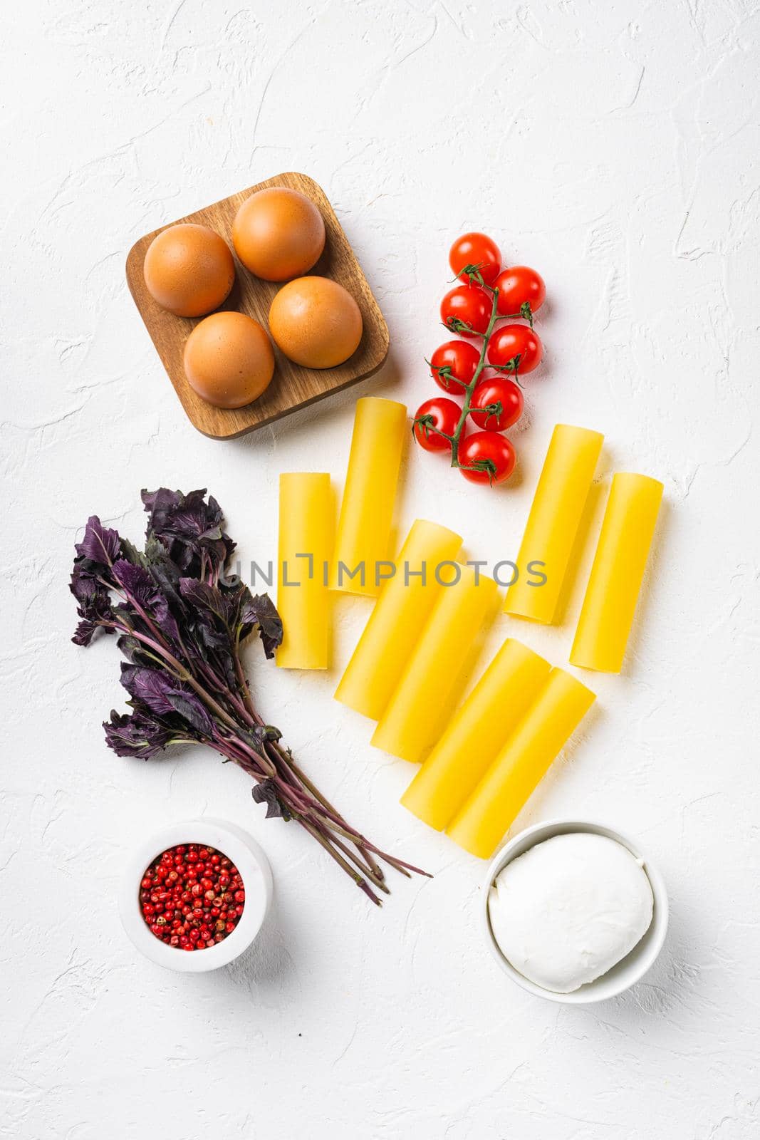 Cannelloni with ingredients set, on white stone table background, top view flat lay