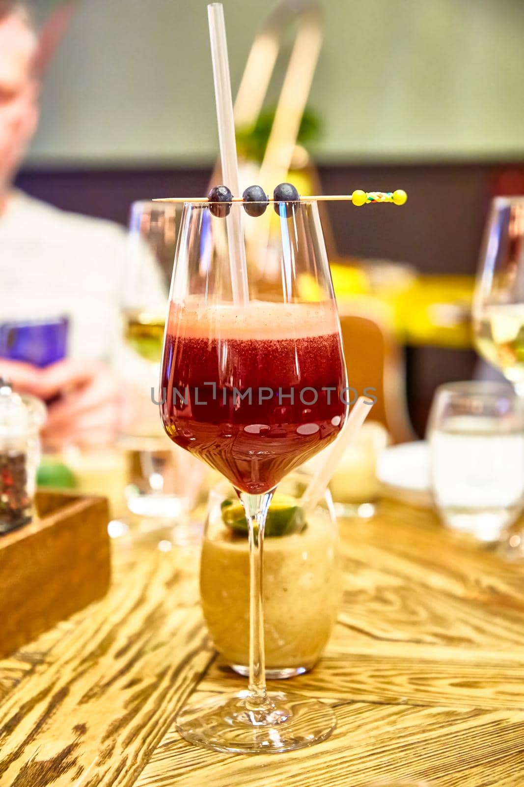 Cocktail or smoothie in a wine glass is on the table by Milanchikov