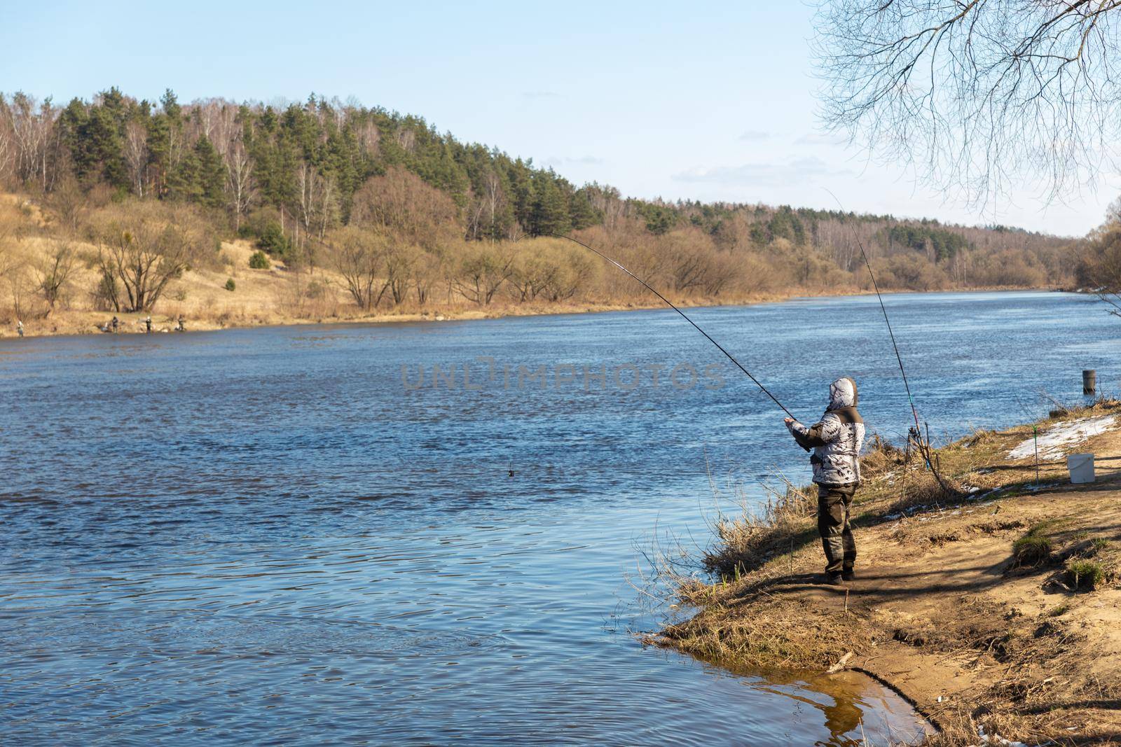 A fisherman fishing with a rod on the shore of river Neman. Grodno, Belarus